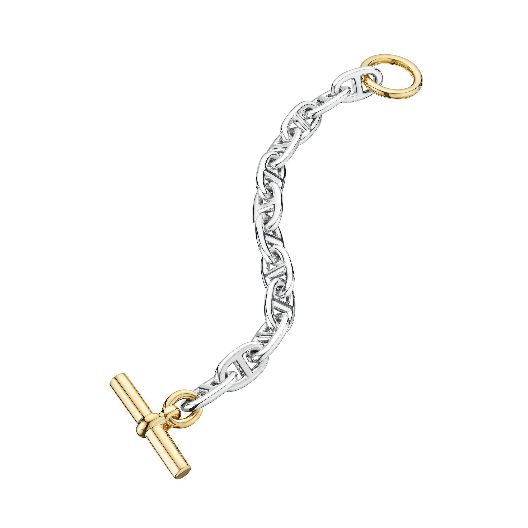 Designed with the captivating combination of 18 karat yellow gold and sterling silver this Hermes Paris modernist chaine d'arce toggle link bracelet is a unique collectible.  With 12 silver anchor chain links and a polished 18 karat yellow gold