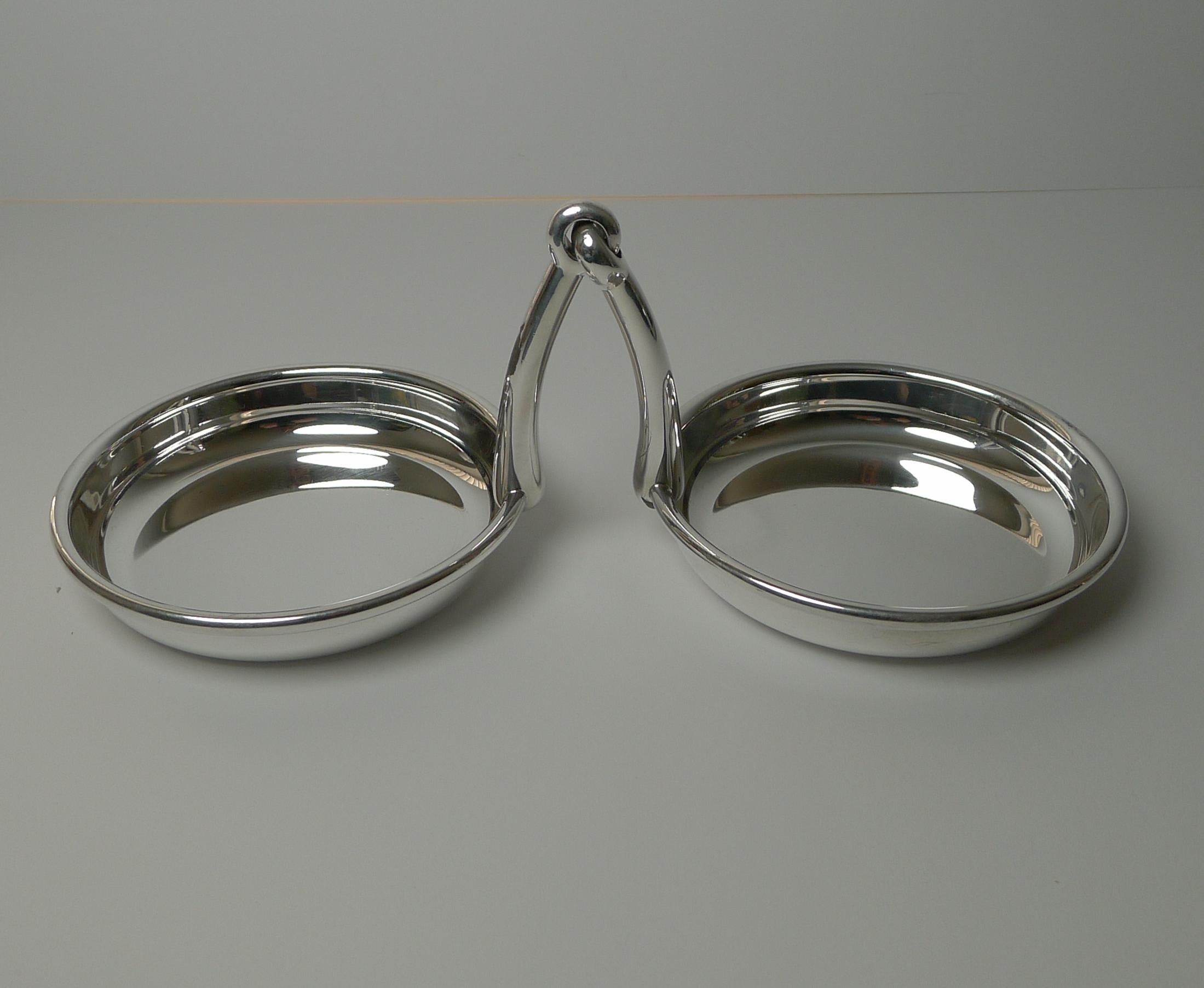 A handsome and rare pair of silver plated dishes or bowls jointed together with a decorative Horse Bit handle in the centre.

Just back from our silversmith's workshop where it has been professionally cleaned and polished, restoring it to it's