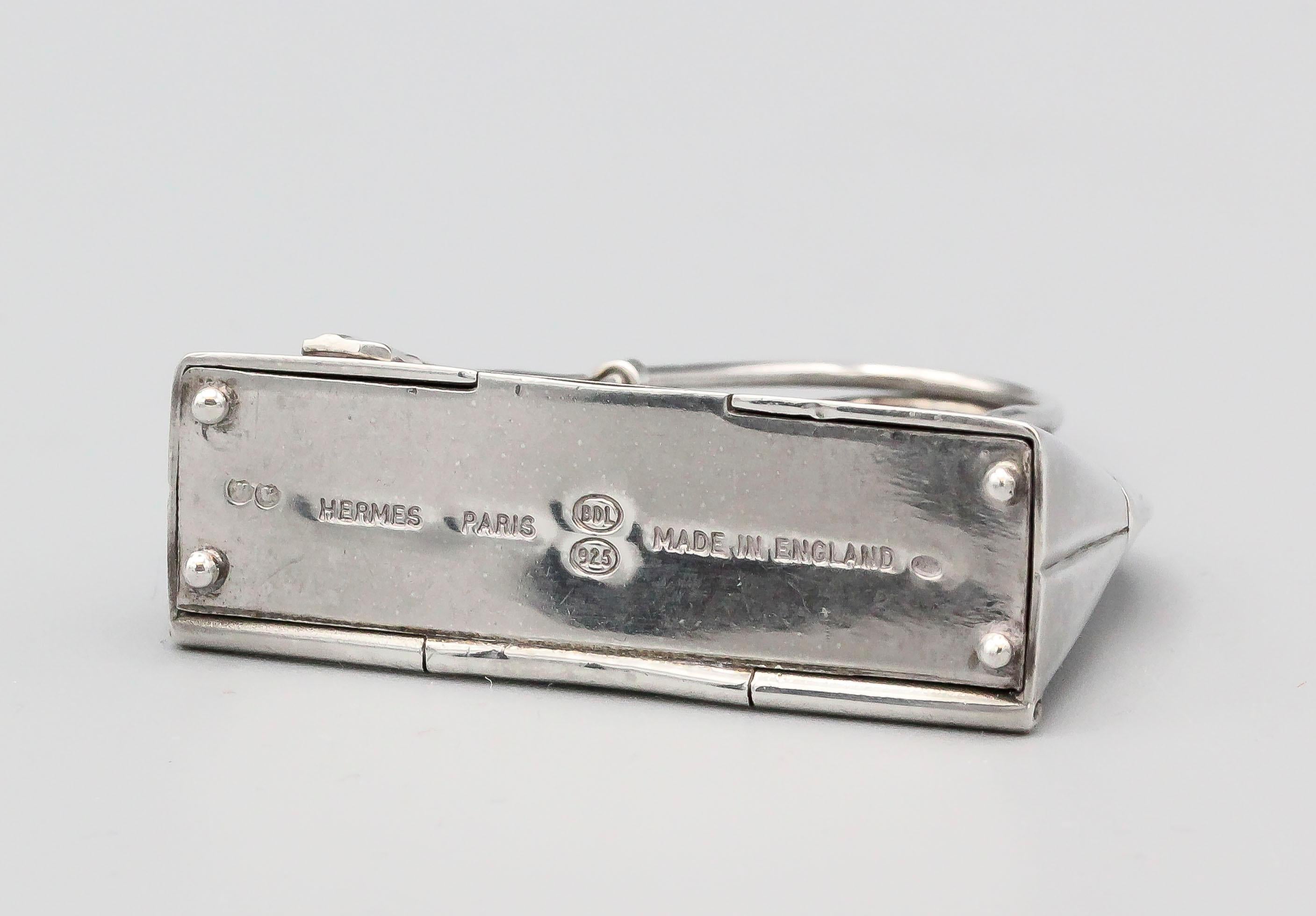 Fine sterling silver pill box in the likeness of an Hermes Bolide bag, by Hermes.  The box can be used in a multitude of ways: as a standard pillbox, a pendant, or as a charm.  Almost 2 inches wide and approx. 30 grams in weight.

Hallmarks: Hermes