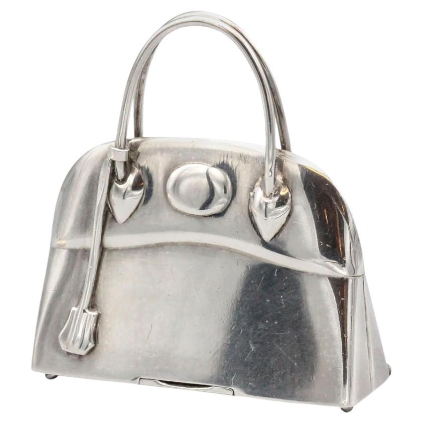 Elevate your style with the exquisite craftsmanship of this Hermes Paris Sterling Silver Bolide Bag Pill Box Charm Pendant. Meticulously crafted, this pendant is a testament to Hermes' legacy of creating exceptional pieces that seamlessly combine