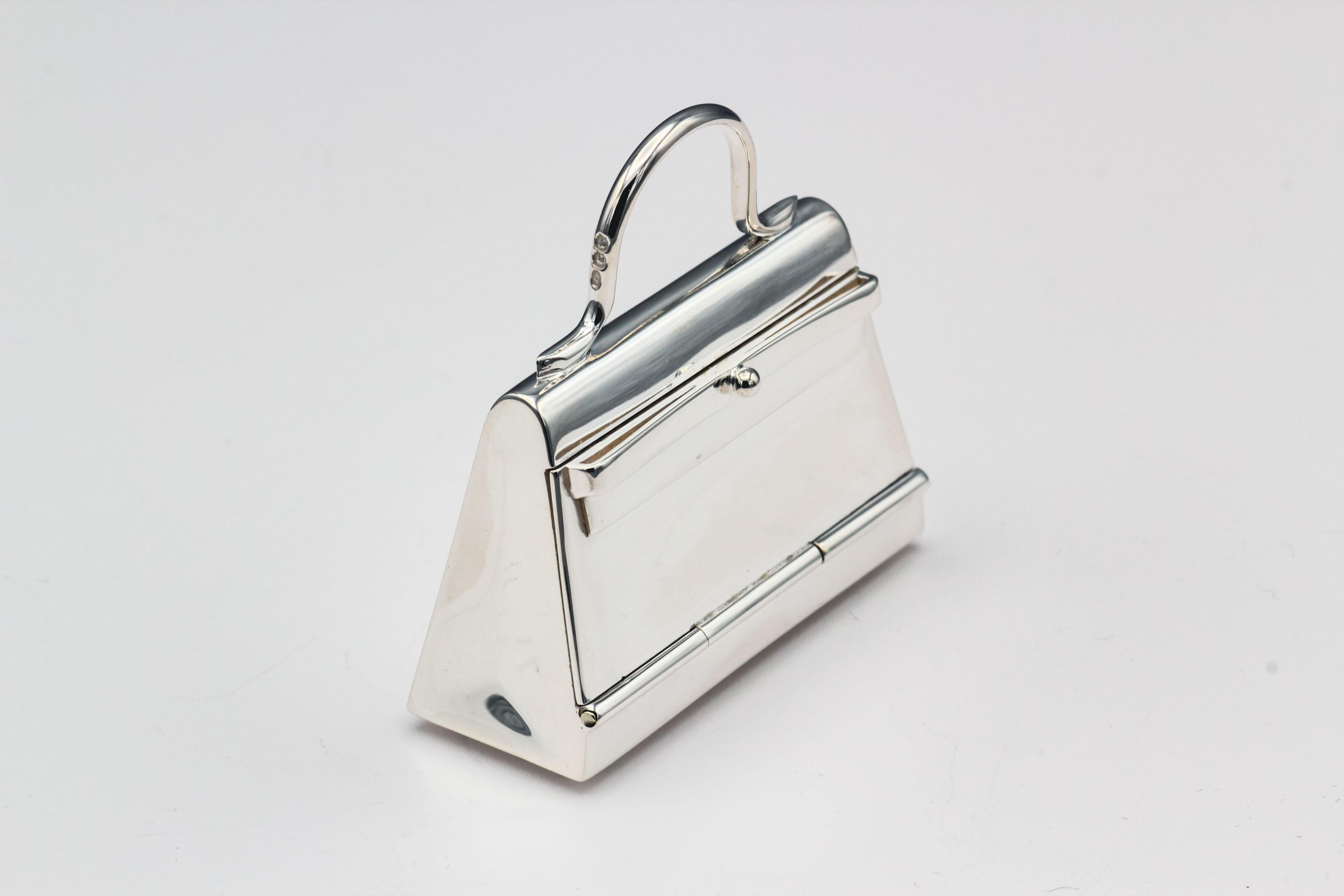 Fine sterling silver pill box in the likeness of an Hermes Kelly bag, by Hermes circa 1980s.  The box can be used in a multitude of ways: as a standard pillbox, a pendant, or as a charm.  Approx. 1.75 inches wide and approx. 39 grams in weight. Like