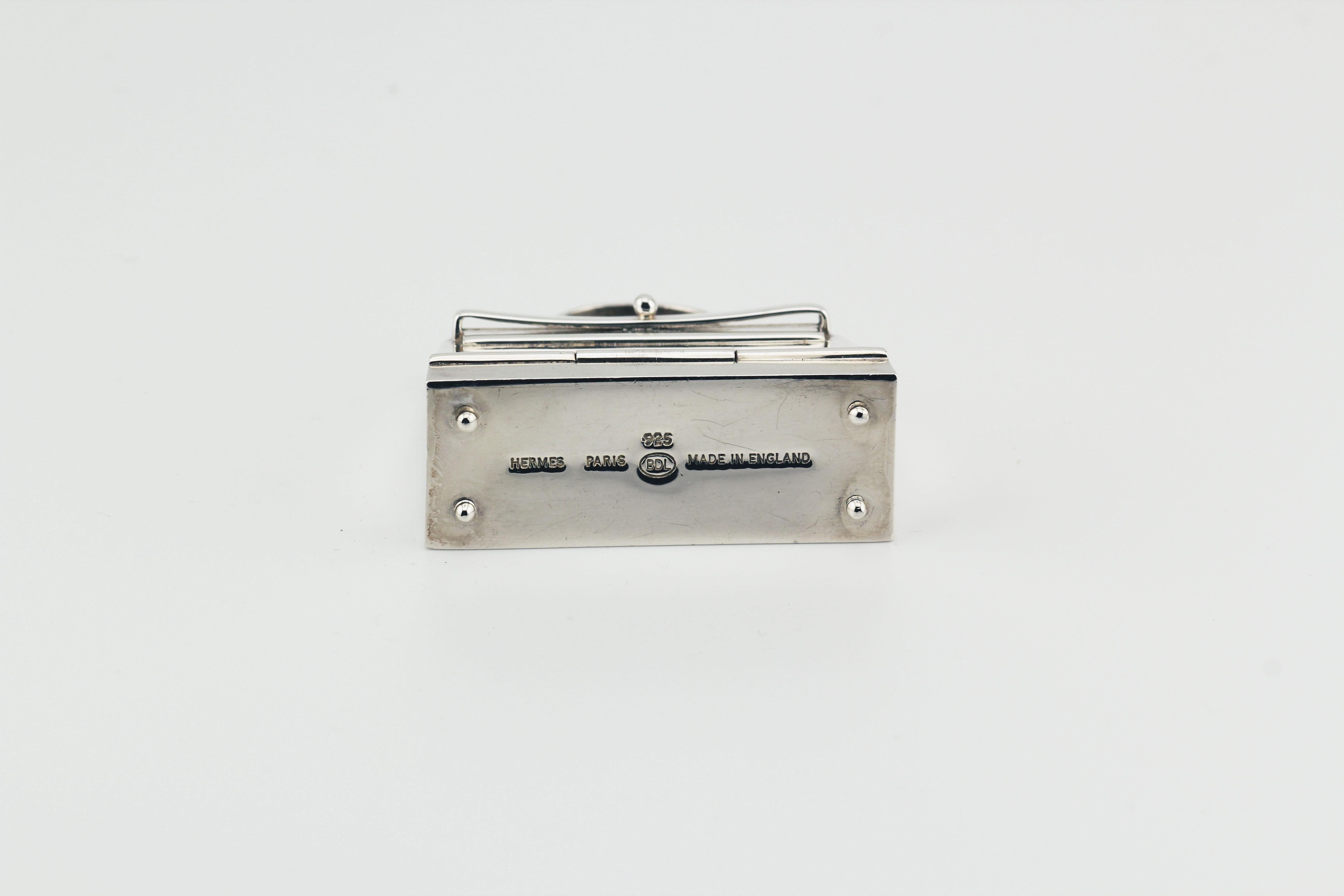 Embrace the epitome of luxury and craftsmanship with this exquisite Hermes Paris Sterling Silver Kelly Bag Pill Box Charm Pendant. Meticulously crafted, this pendant is a testament to Hermes' legacy of creating exceptional pieces that seamlessly