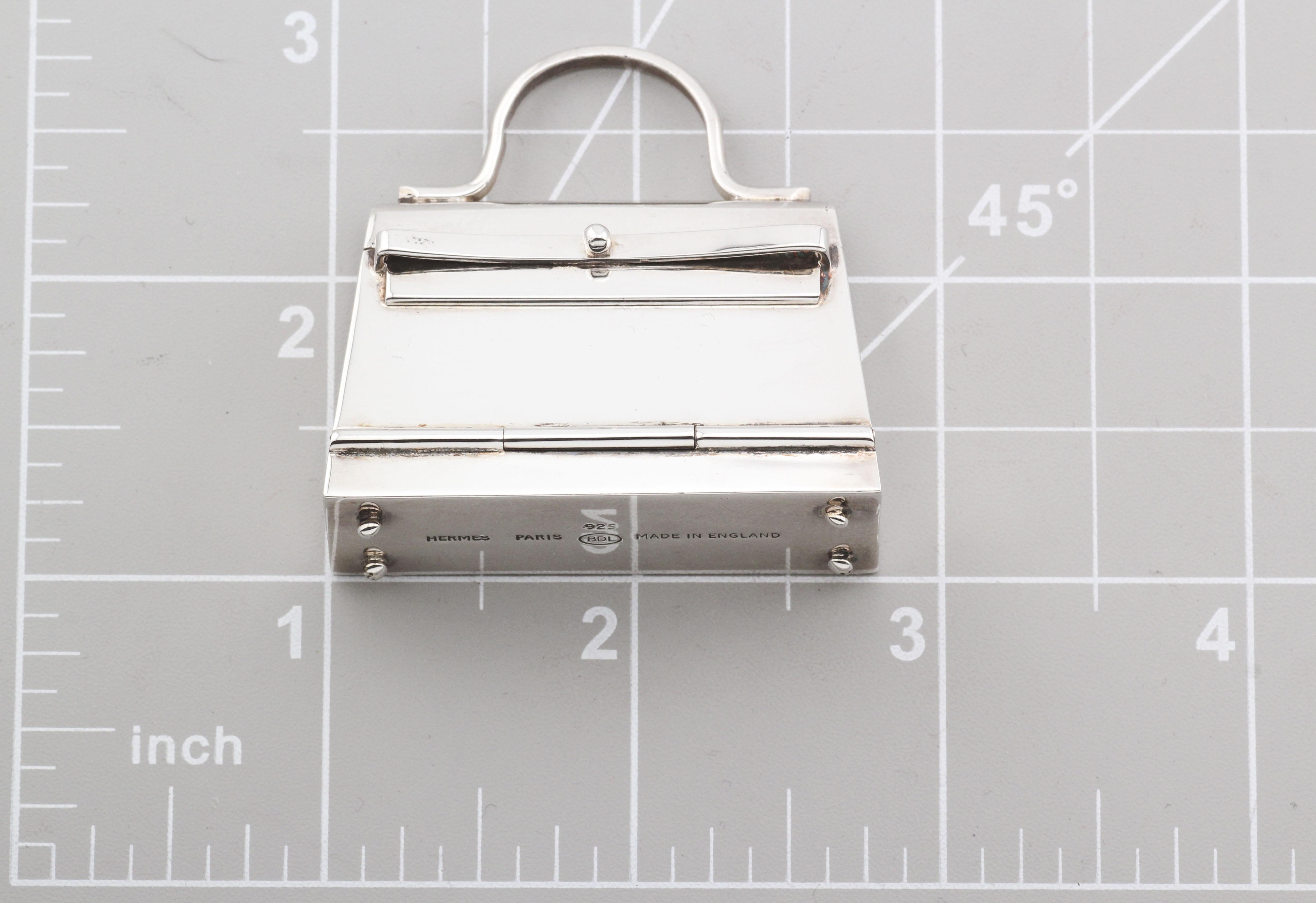 Ce pendentif à breloque en argent sterling Hermes Paris Kelly Bag Pill Box est l'incarnation même du luxe et de l'artisanat. Méticuleusement réalisé, ce pendentif témoigne de l'héritage d'Hermès en matière de création de pièces exceptionnelles qui