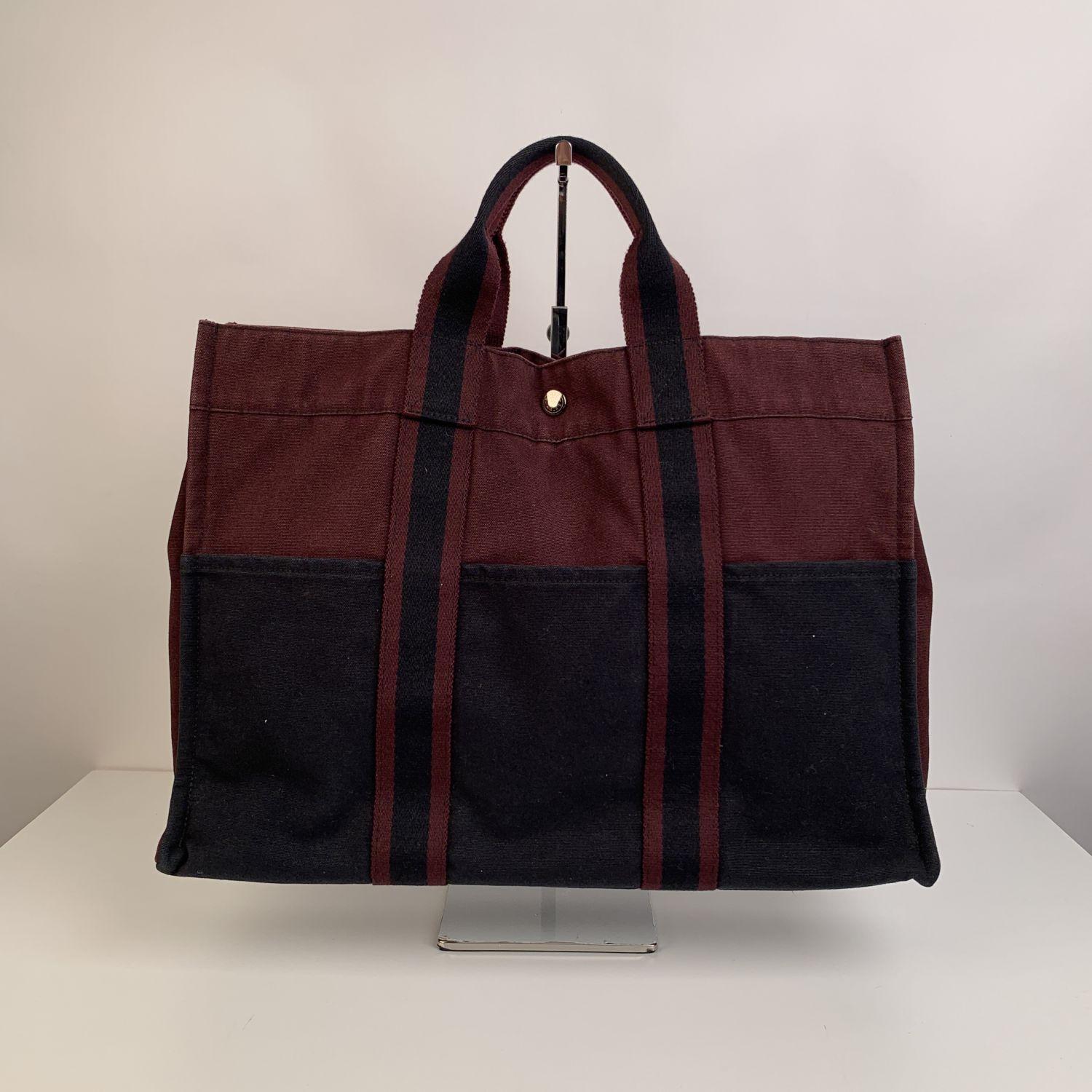 Model: 'HERMES FOURRE TOUT - MM' - Bicolor Tote handbag. Made in France, Brown and Black background with contrast stripes. Material: 100% cotton. It has snaps on both ends for expansion. Durable canvas handles, perfect for casual and everyday use.