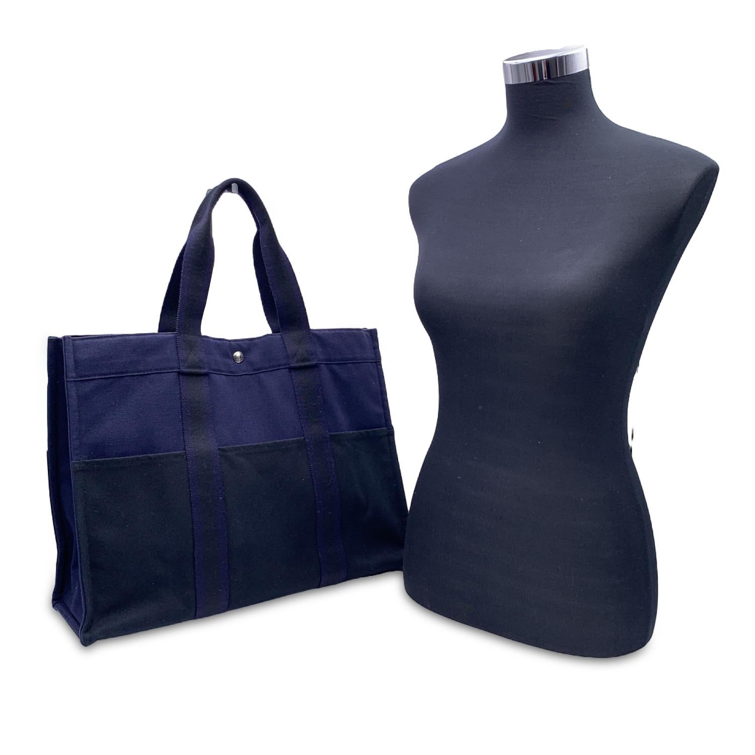 'HERMES FOURRE TOUT - GM' - Tote handbag. Made in France. Blue color with black stripes. Material: 100% cotton. It has snaps on both ends for expansion. Durable canvas handles, perfect for casual and everyday use. 3 open pockets on the front and 3