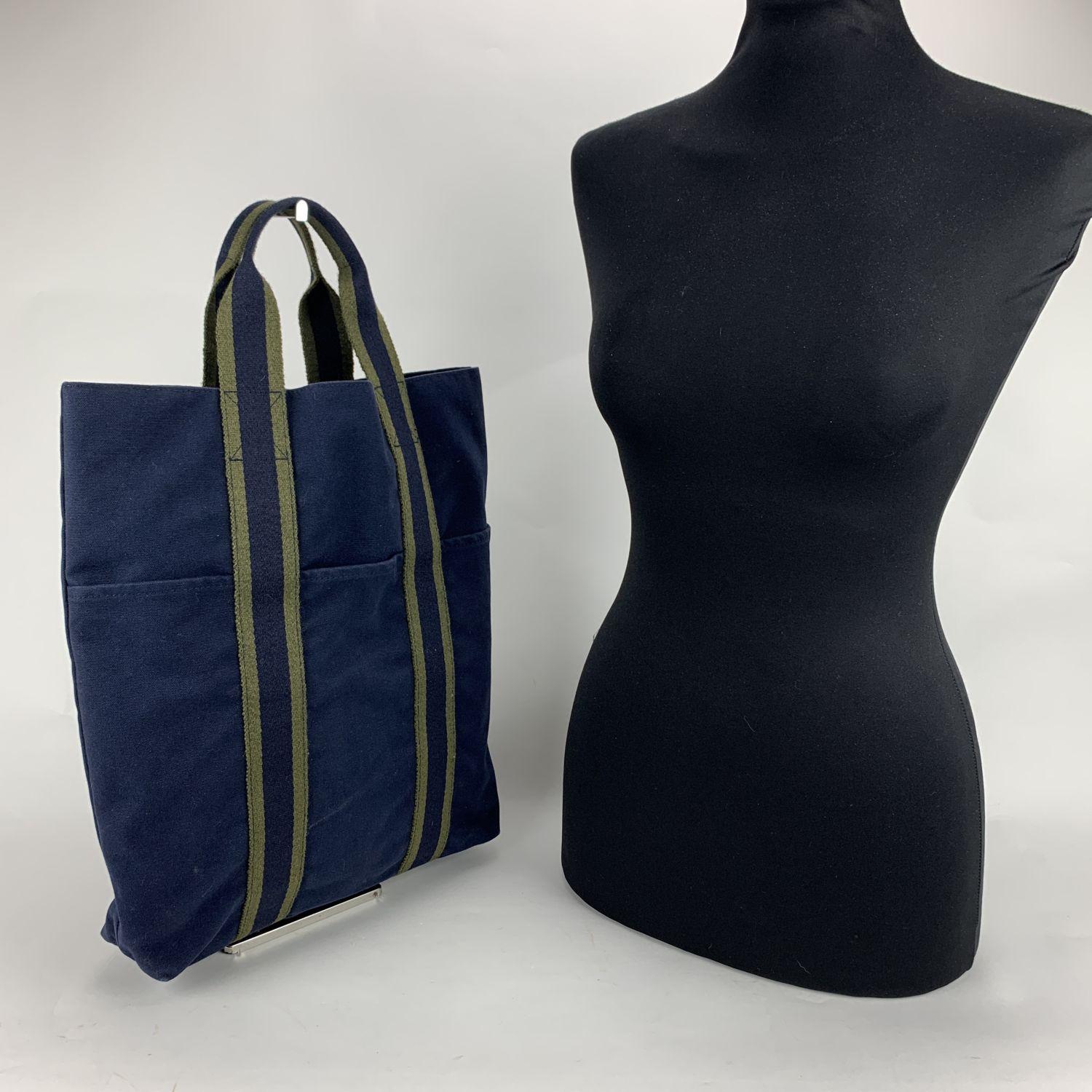 Model: 'HERMES Vertical FOURRE TOUT ' Shopping Bag. Made in France. Blue color with Green stripes. Material: 100% cotton. Durable canvas handles, perfect for casual and everyday use. Open top. 3 open pockets on the front. Canvas internal lining. 1