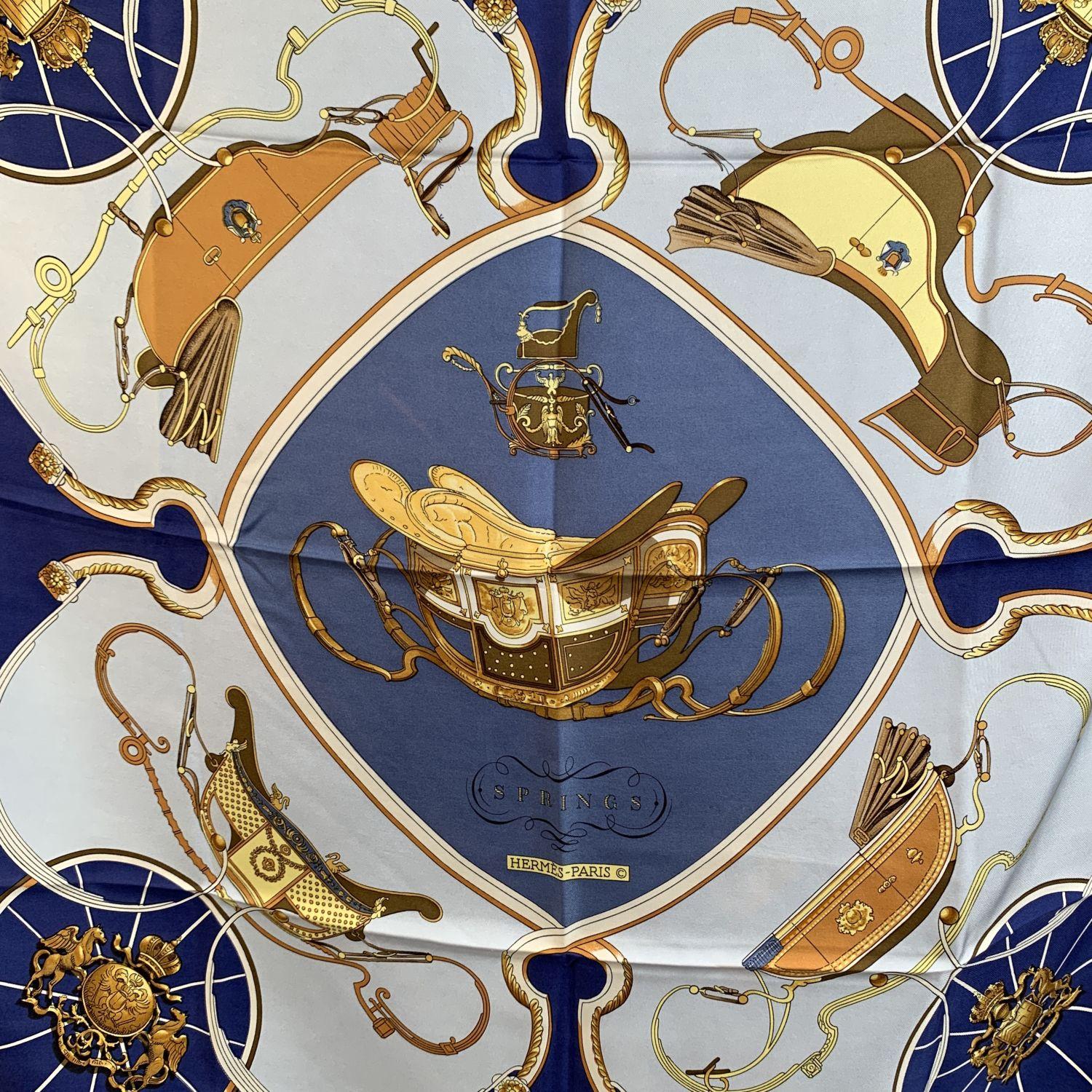 Hermes Paris Vintage Silk Scarf 'Springs' . It depicts in its center the phaeton carriage belonging to Napoleon I's son. Artist :Philippe Ledoux. First Issue : 1974. Blue, Gray, Yellow colors. Hand rolled hem. Fabric / Material: 100% Silk. Approx