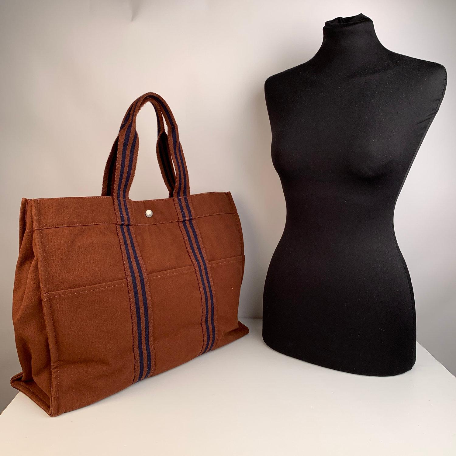 - Hermes Paris Vintage Brown Cotton Canvas Tote Handbag Fourre Tout GM.
- Made in France
- Brown and navy blue colors
- Material: 100% cotton
- 3 front pockets on the front and 3 pockets on the back
- It has snaps on both ends for expansion
-