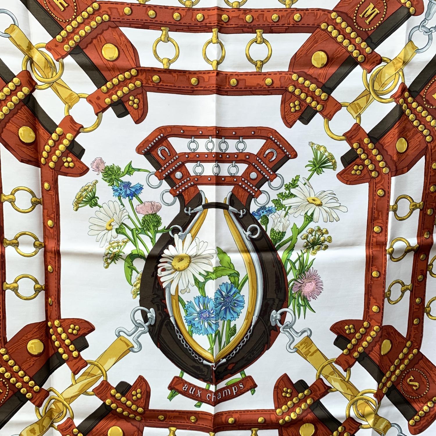 HERMES Silk scarf named 'Aux Champs', created by artist Cathy Latham, and first issued in 1970. 100% Silk. Hand rolled edges. Brown colorway. 'HERMES Paris' signature with copyright symbol is located in the center. Approx measurements: 35 x 35