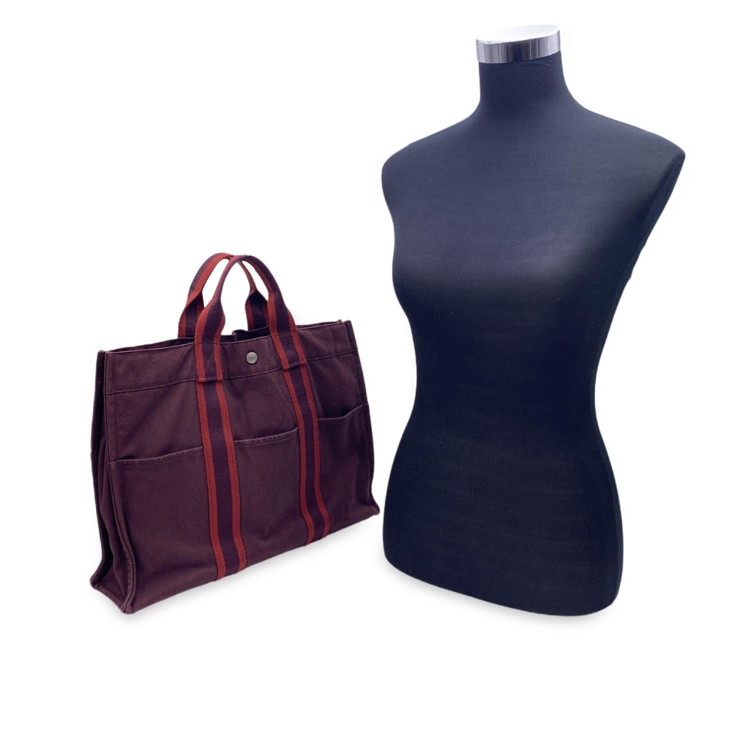 HERMES FOURRE TOUT - MM' - Tote handbag. Made in France. Brown/burgundy color with red stripes. Material: 100% cotton. It has snaps on both ends for expansion. Durable canvas handles, perfect for casual and everyday use. Open top with middle snap