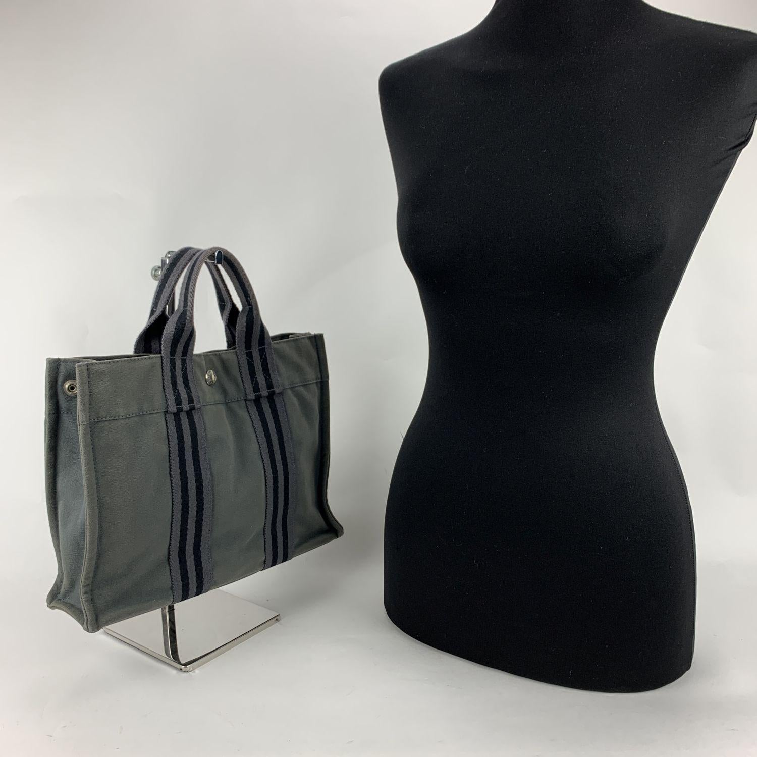 Model: 'HERMES FOURRE TOUT - PM' Tote handbag. Made in France. Grey and black stripes. Material: 100% cotton. It has snaps on both ends for expansion. Durable canvas handles, perfect for casual and everyday use. Open top with middle snap closure