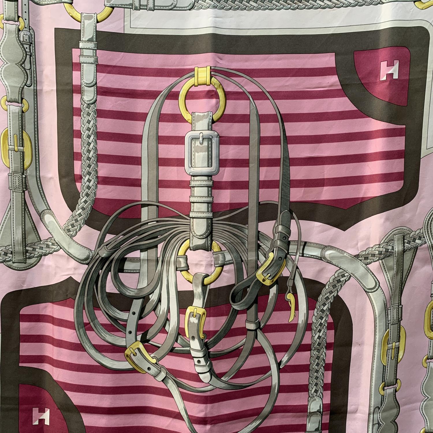 HERMES silk scarf named 'Coaching' , designed by Julie Abadie and issued the first time in 1976. Main colors are pink, purple, grey and yellow. It depicts different elements participating in the horse's harness. Hand rolled edges. Measurements: