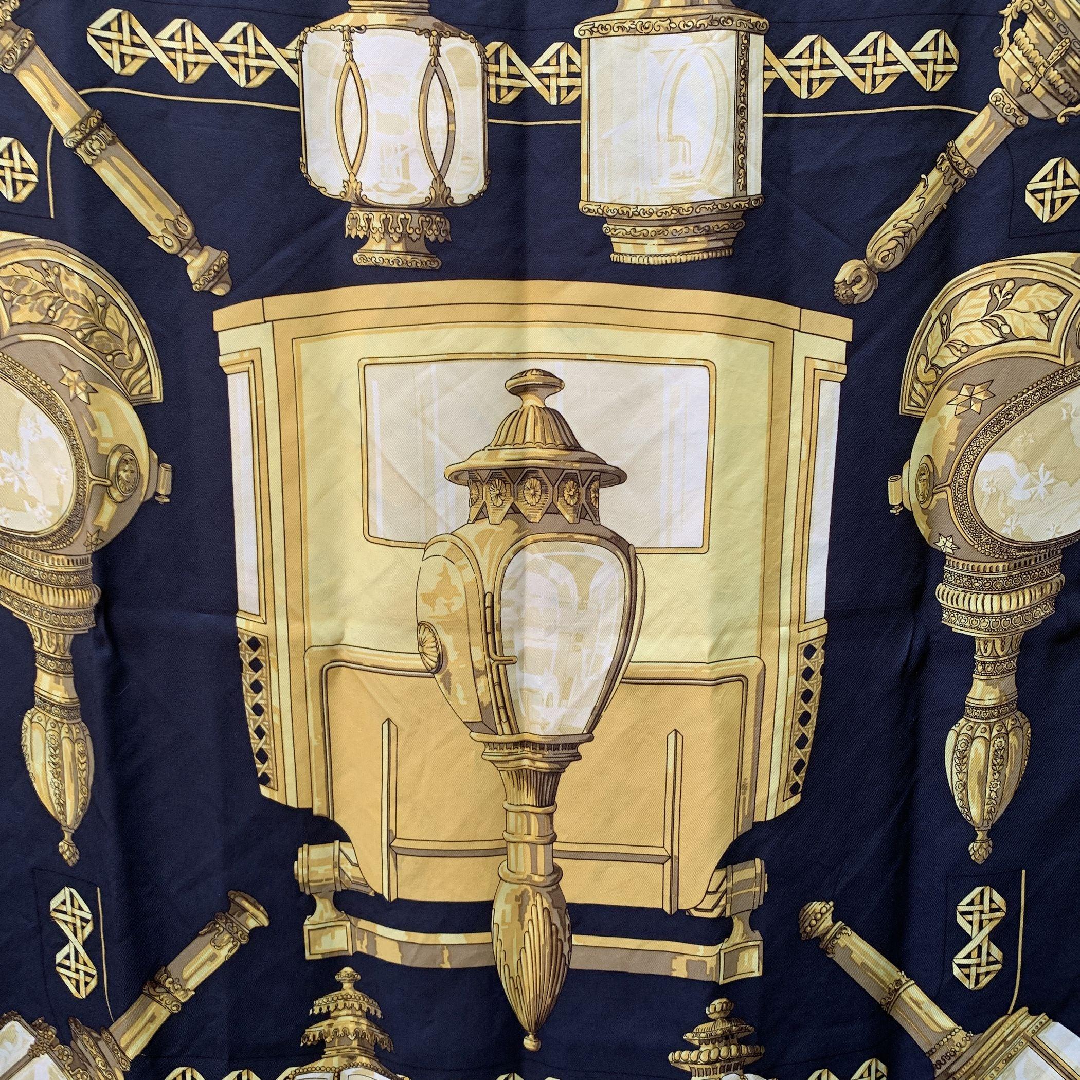 HERMES scarf 'Feux de Route' by Caty Latham and originally issued in 1971. It has re-issued many times, in different colours, formats and variations of. It features a coach in the center surrounded by oversize carriage lights. Colors: Yellow Gold