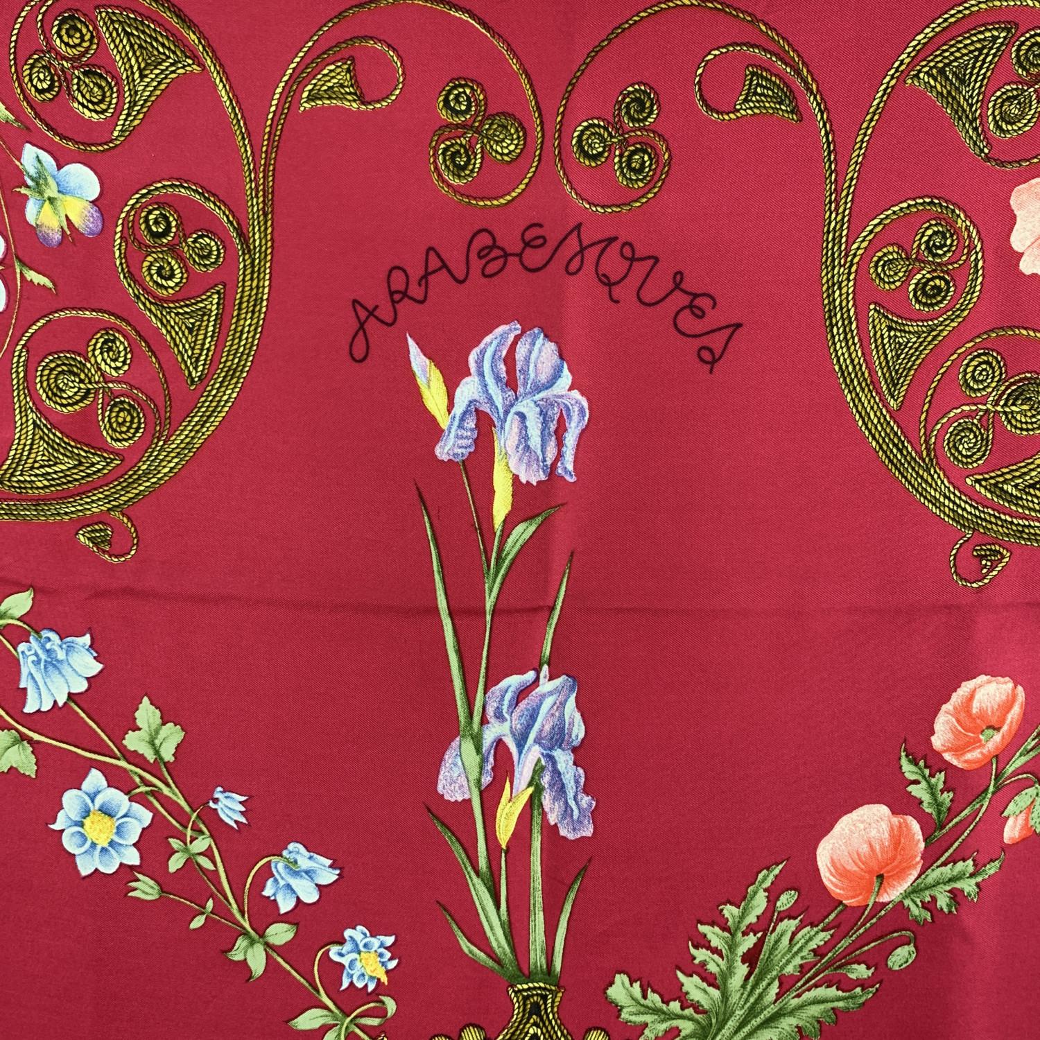 HERMES silk scarf named 'Arabesques ', by Henri d'Origny designed - first issued in 1963. 100% Silk. Multicolor floral design with magenta background and purple borders. Measurements: Approx 35 x 35 inches. 'HERMES PARIS' printed in the bottom