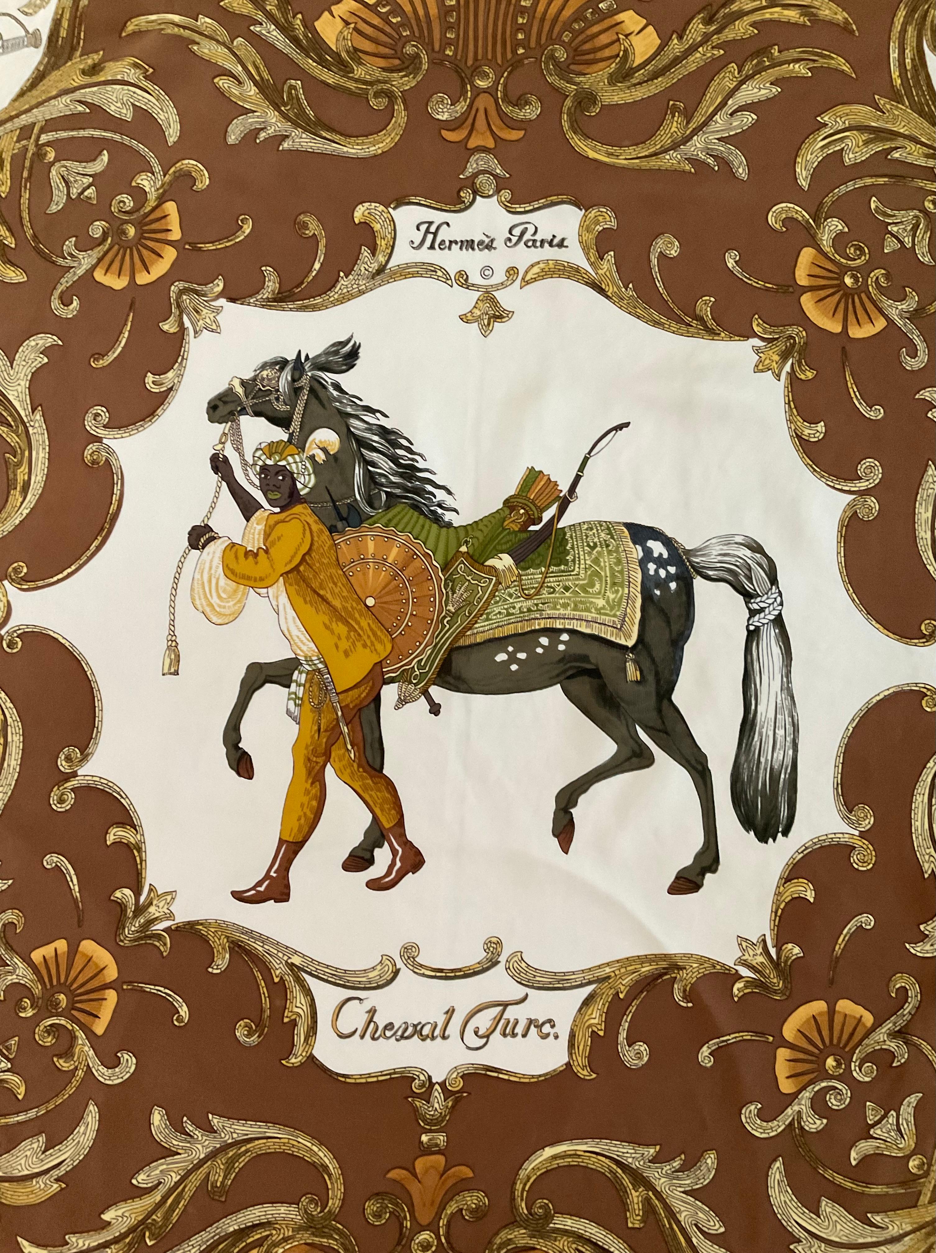 Pieza rara y cautivadora de los años 80, este pañuelo de seda Hermès, Cheval Turc, fue diseñado por Christiane Vauzelles. Inspirada en la elegancia de los caballos turcos, presenta intrincados motivos ecuestres y bordes ornamentados en una rica