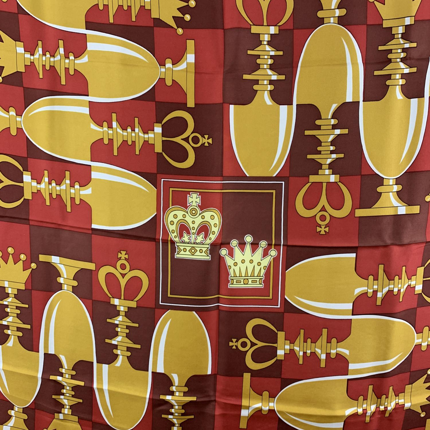 Beautiful Hermes 'Echecs II / Echiquier' silk scarf by Pierre Peron, originally issued in 1974. It has re-issued many times in different colours, formats and variations of. Main color are red, brown and yellow gold. The scarf depicts a chessboard