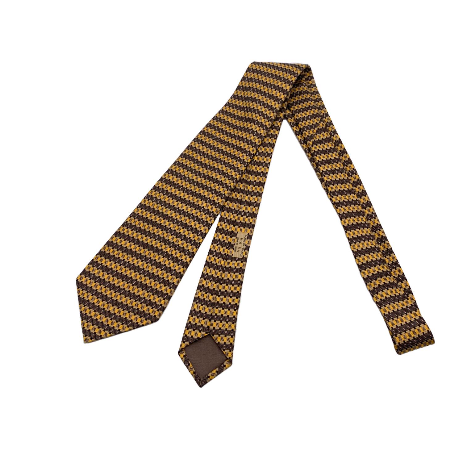 Elegant Hermes Neck Tie, 816 EA, in yellow and brown colors. Composition: 100% Silk. Hermes composition tag attached. 'HERMES Paris' with copyright symbol printed on the back. Made in France. Total length: 59.5 inches - 151.2 cm. Max width: 3.5