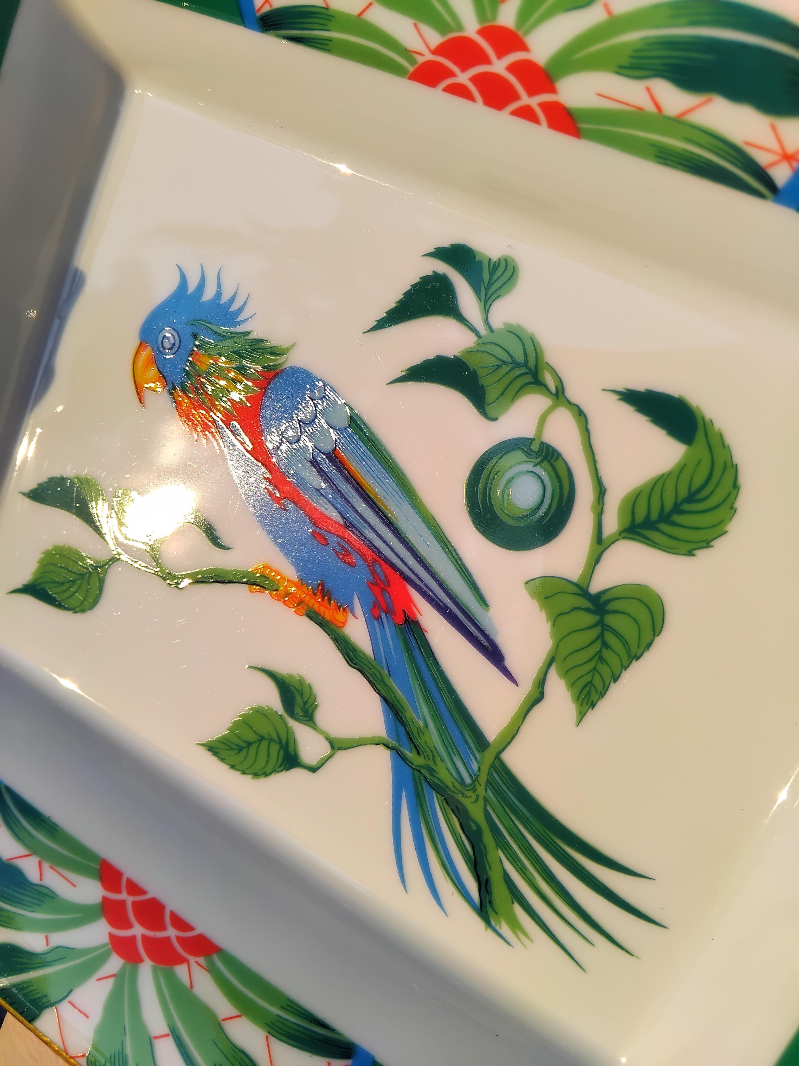 Schöner authentischer Hermès Aschenbecher

Drucken: Papagei

Tolle Geschenkidee für einen Papageienliebhaber!

Hergestellt in Frankreich

Vintage By

Aus Porzellan, Ränder und Kerben von Hand mit Feingold bemalt

Sockel mit grünem Wildleder bezogen,