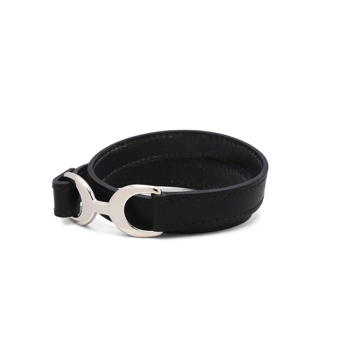 Authentic Hermès 'Pavane Double Tour' bracelet crafted in black leather. This classic bracelet is designed as a wrap around and detailed with perceptible stitching. It features a palladium plated buckle and can fit up to a size 7 inch wrist