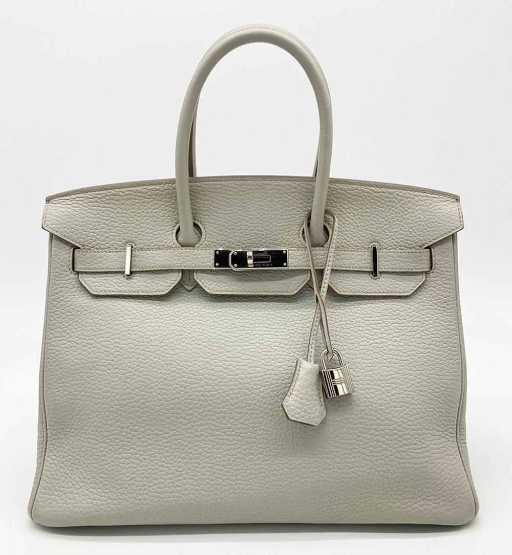 Hermes Pearl Grey Birkin 35 in excellent condition. Rare pearl grey clemence leather exterior trimmed with silver palladium hardware. Signature triple notch top flat double strap birkin twist lock closure opens to a matching kidskin lined interior
