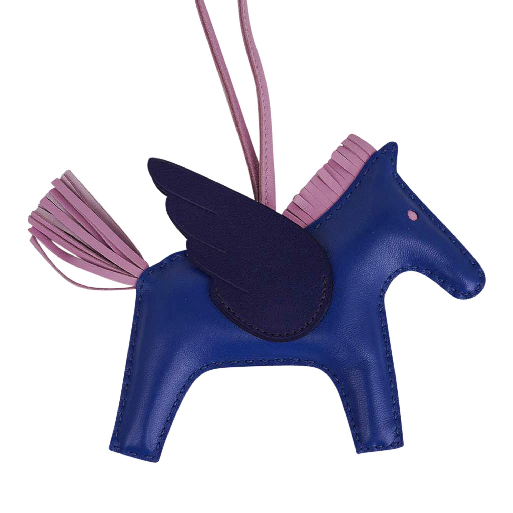 Mightychic offers an Hermes Grigri Pegase Rodeo PM featured in Bleu de France 
with Mauve Sylvestre mane and tail, and Bleu Saphir wings. 
Leather is lambskin Milo.
Signature HERMES PARIS MADE IN FRANCE is stamped under saddle.
New or Pristine Store