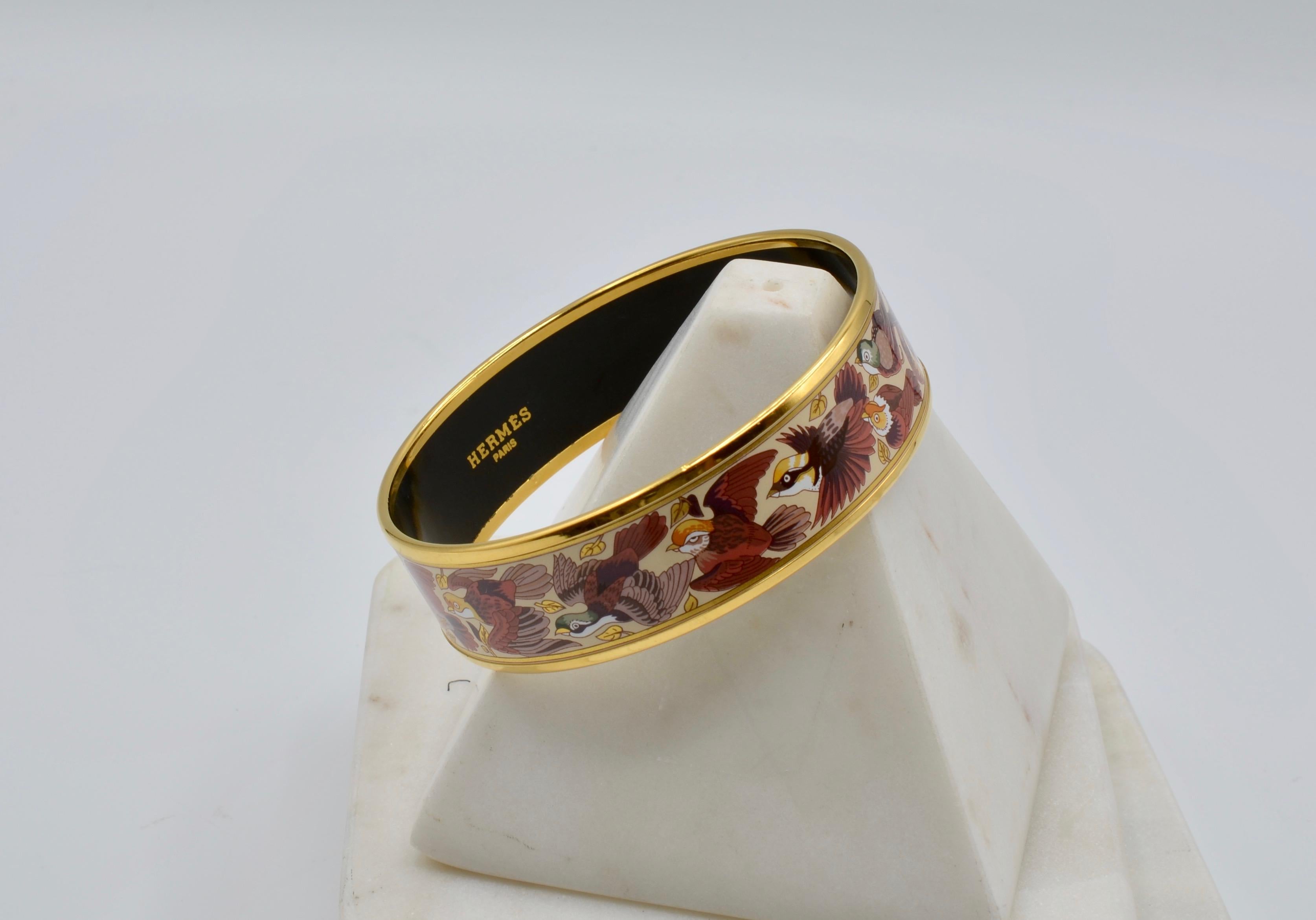 This Hermes cuff has a pheasant motif in a maroon color combo on a ivory background . The bracelet is made in Austria of enamel and heavy gold plating. the circumference measures 8.25 inches. This one is a great addition to your collection! Box and