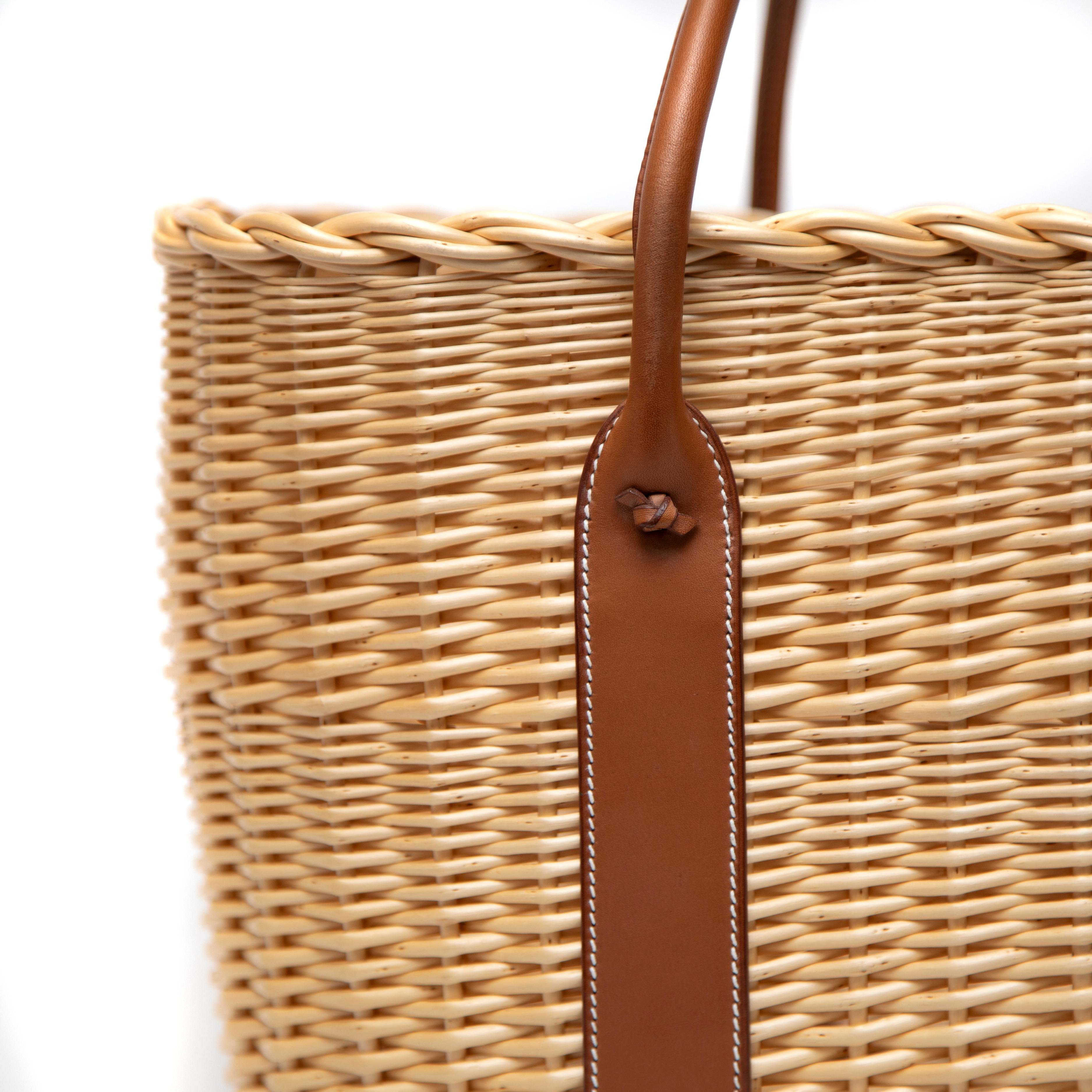 The Hermès Picnic Garden Party, released as a Limited Edition in 2012, is a striking fusion of luxury and rustic charm. Crafted from woven wicker and Barénia leather, this bag exemplifies Hermès' dedication to exquisite craftsmanship and timeless