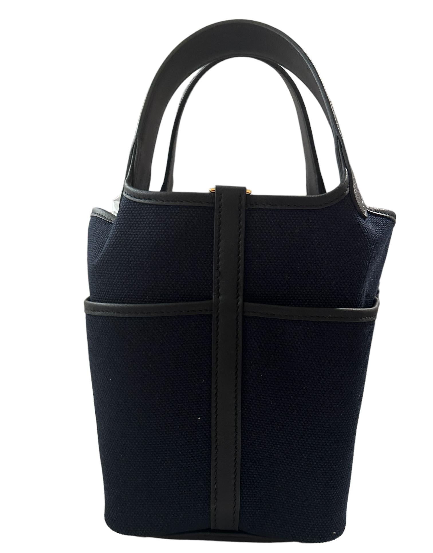 Hermes
New Cargo Picotin with Pocket
This Cargo Picotin Lock is in Bleu Marine and Black swift leather and toile with gold hardware and has tonal stitching, four exterior pockets with two top handles.

The interior is lined with natural leather, no