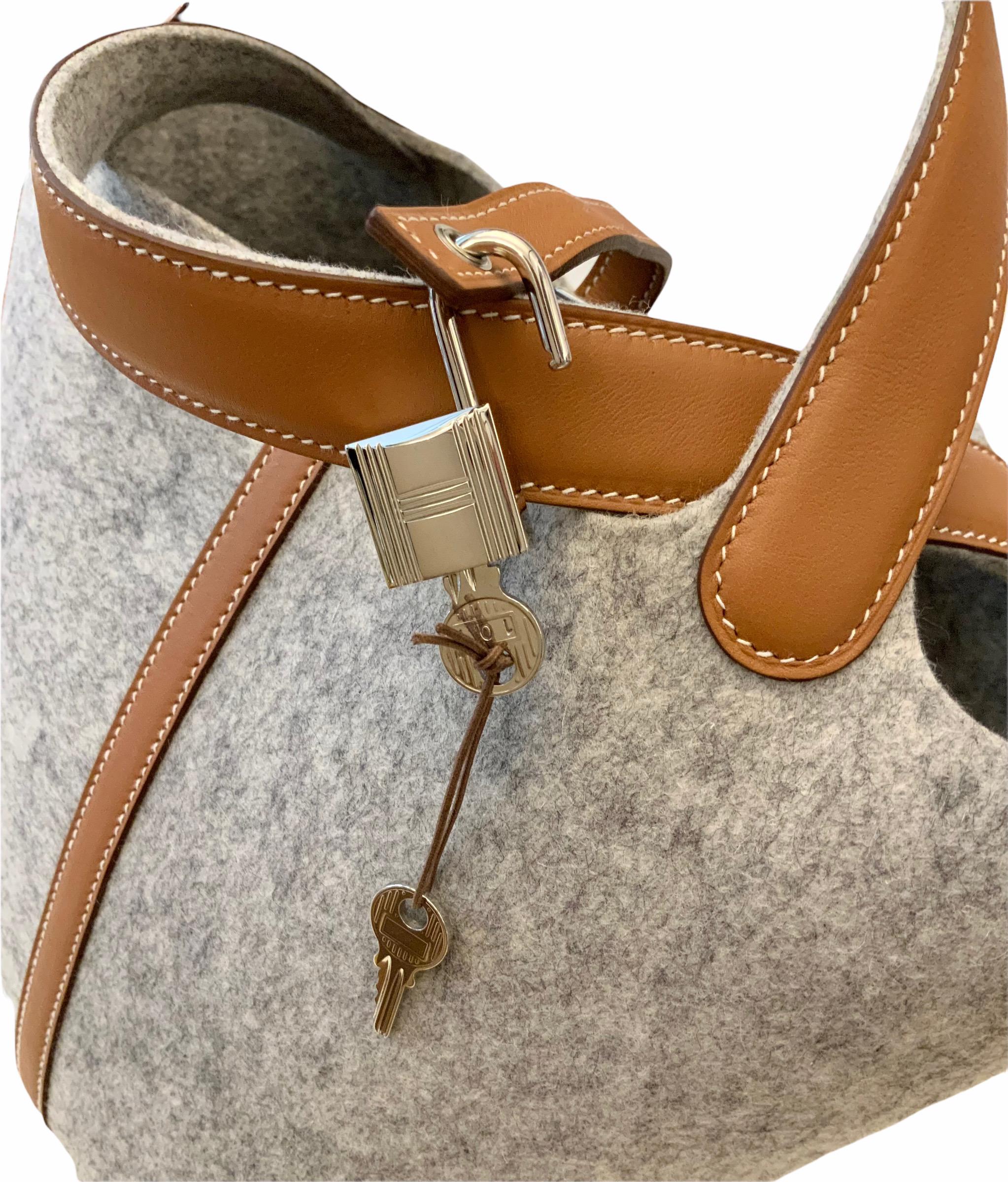This pre-owned but as new Picotin Lock 18 bag is a Limited Edition of the Picotin Line.
Using Felt as the main material, it is holding its shape well and can be used for a longer time than the leather versions.
Its Barenia leather trim with