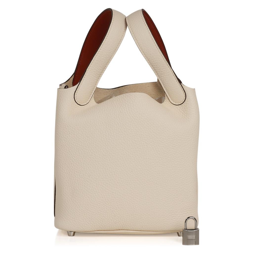 Guaranteed authentic Hermes Picotin Eclat Lock 18 tote bag in Nata / Battue.
The bag is Nata, a beautiful cream, with the interior of the handles Battue, a contrasting sienna.
The interior of the handle is Swift leather.
The body of the bag and