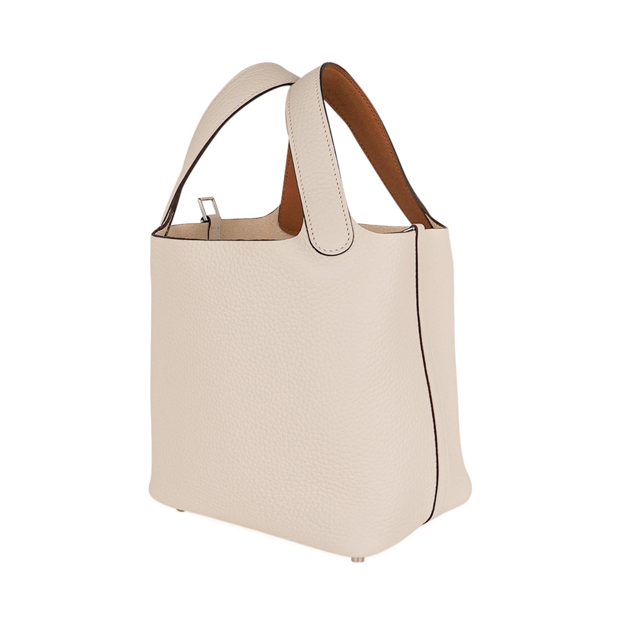 Hermes Picotin Eclat Lock 18 tote bag in Nata and Sesame.
The bag is Nata, a beautiful chalk white, with the interior of the handles Sesame, a contrasting warm tone.
The interior of the handle is Swift leather.
The body of the bag and exterior