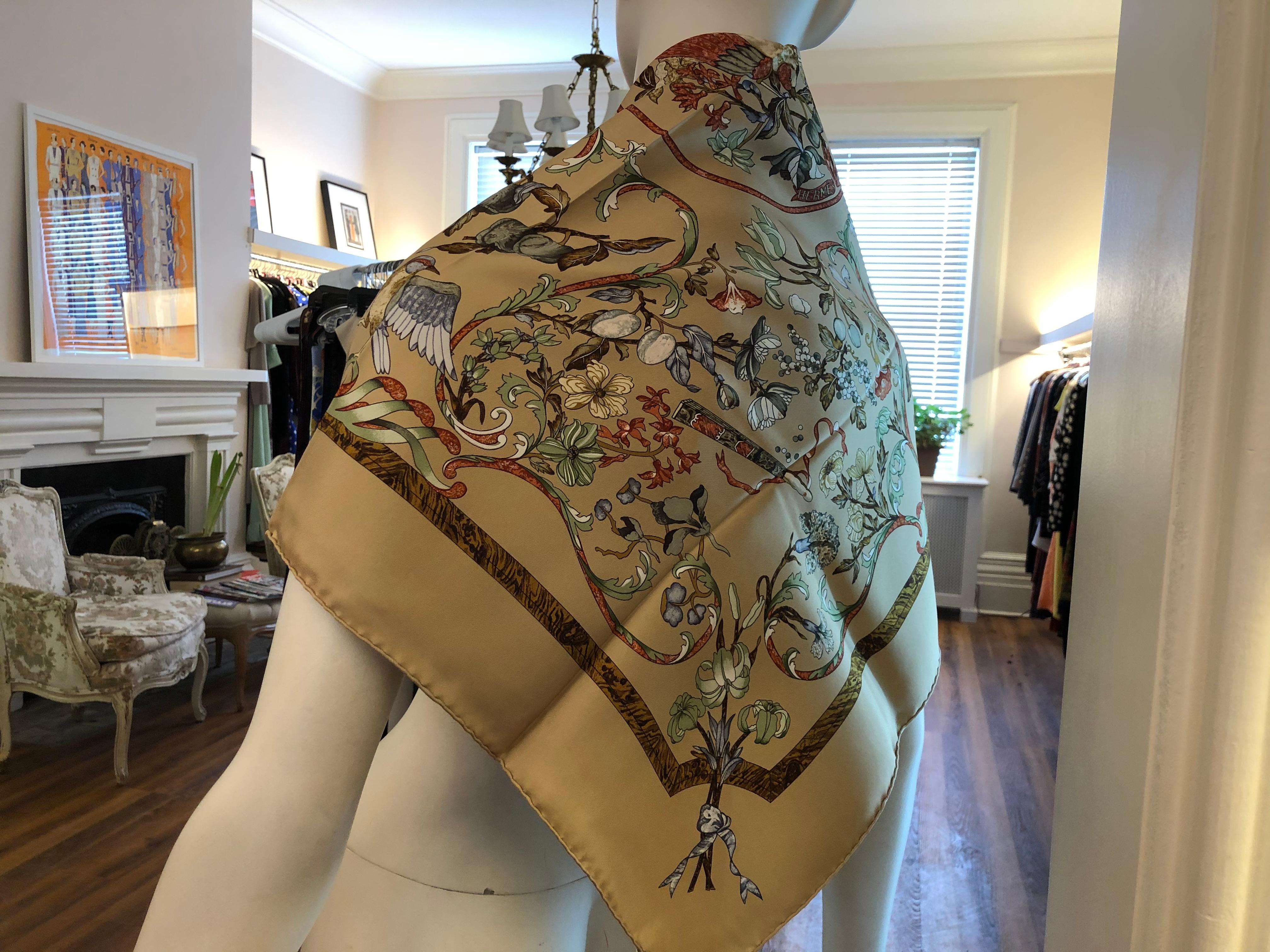 Lovely Hermes silk scarf designed in 1988 by Zoe Pauwells. This scarf has a beige background with a multicolored bird and floral designs. Its is signed, has its care tag and hand rolled hems.