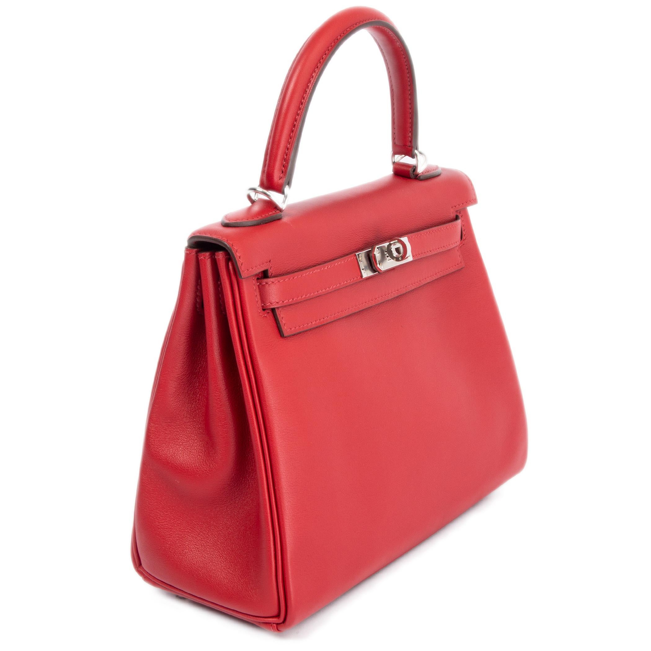 100% authentique sac Hermes Kelly 25 Retourne en cuir Rouge Piment red Veau Swift avec des accessoires en palladium. Doublé en Chevre (peau de chèvre) avec une poche ouverte sur le devant et une poche zippée au dos. Neuf - Set