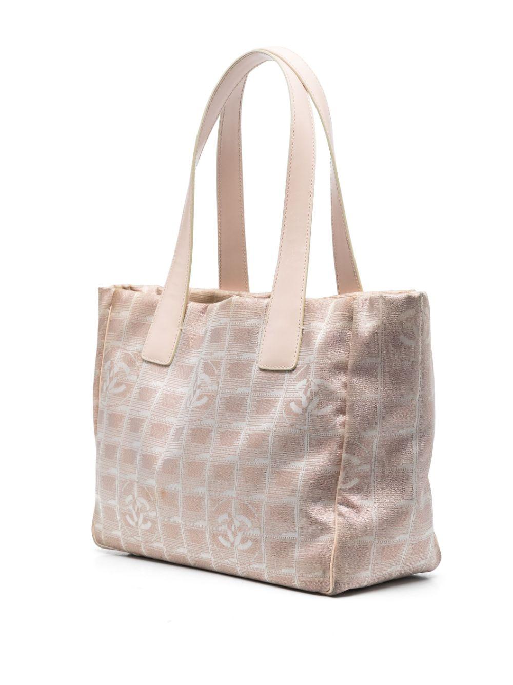 Chanel rosafarbene Travel Line Tragetasche in kleinerem Format mit dem ikonischen CC-Leinwanddruck, rosafarbenen Ledergriffen und einem Etikett. 
Circa 1990er Jahre
In gutem Vintage-Zustand. Hergestellt in Frankreich. 
Wir garantieren Ihnen, dass