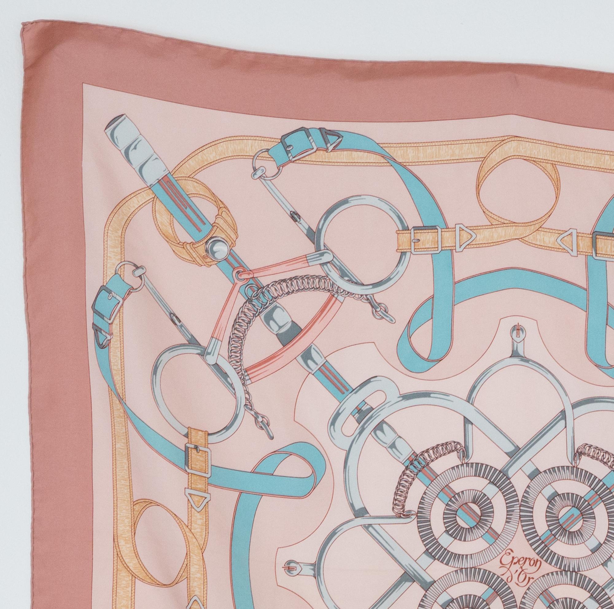 Hermes silk scarf Eperons d'Or by H. d'Origny featuring a light pink ground.
In good vintage condition. Made in France.
35,4in. (90cm)  X 35,4in. (90cm)
We guarantee you will receive this  iconic item as described and showed on photos. (please