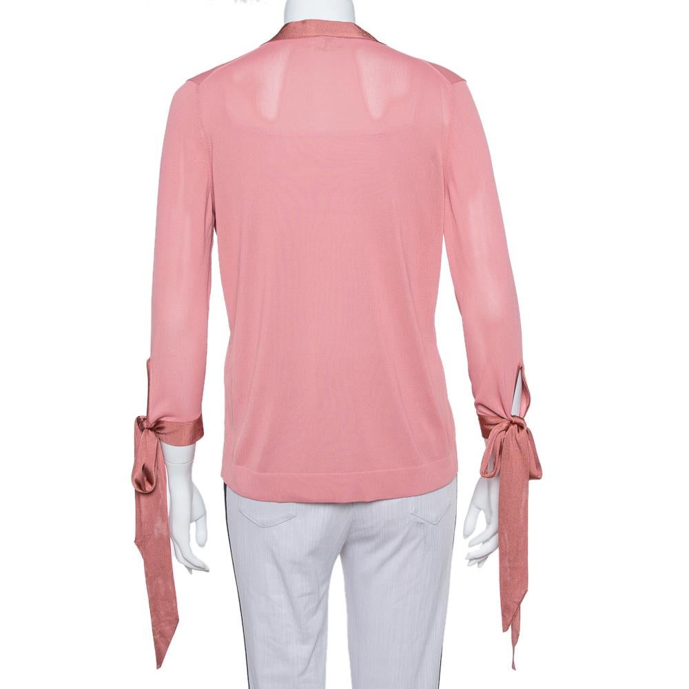 A blend of comfort and style, this Hermes top is exactly what one needs in a top. This striking pink creation features a V neckline and tie details on the sleeves. You can pair the top with pants as well as skirts.

