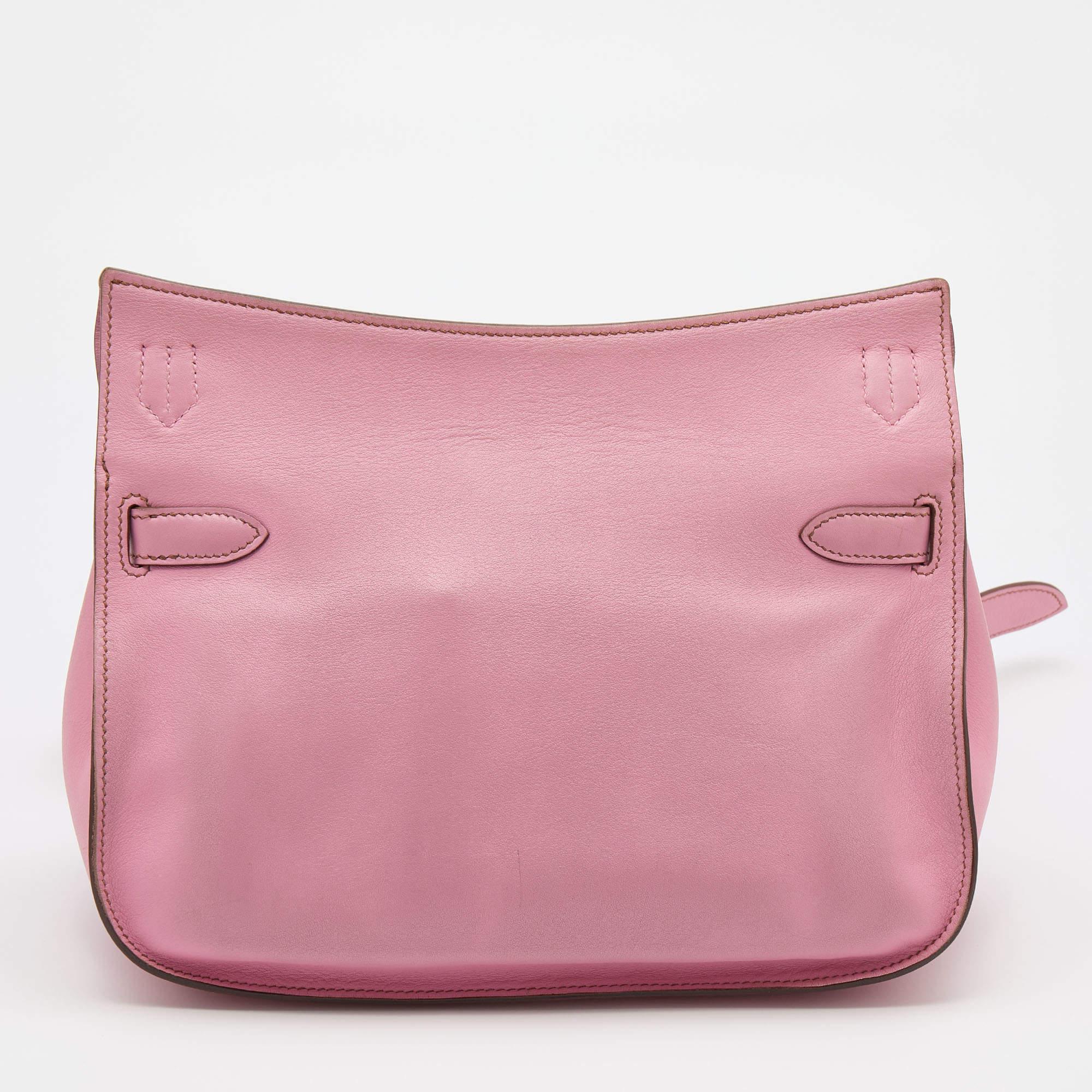 The Jypsiere comes in a design that delightfully resembles the famous Hermes Birkin and Kelly. It is a more casual design of the iconic handbags. This here comes crafted from pink Swift leather and is equipped with a spacious interior. Complete with