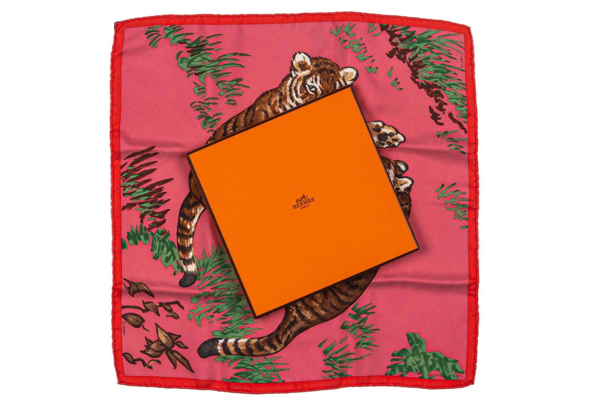 Foulard en soie Hermès Tigers en excellent état. Fond rose avec bordure rouge représentant de grands tigres bondissants. Bords roulés. Livré avec sa boîte d'origine.