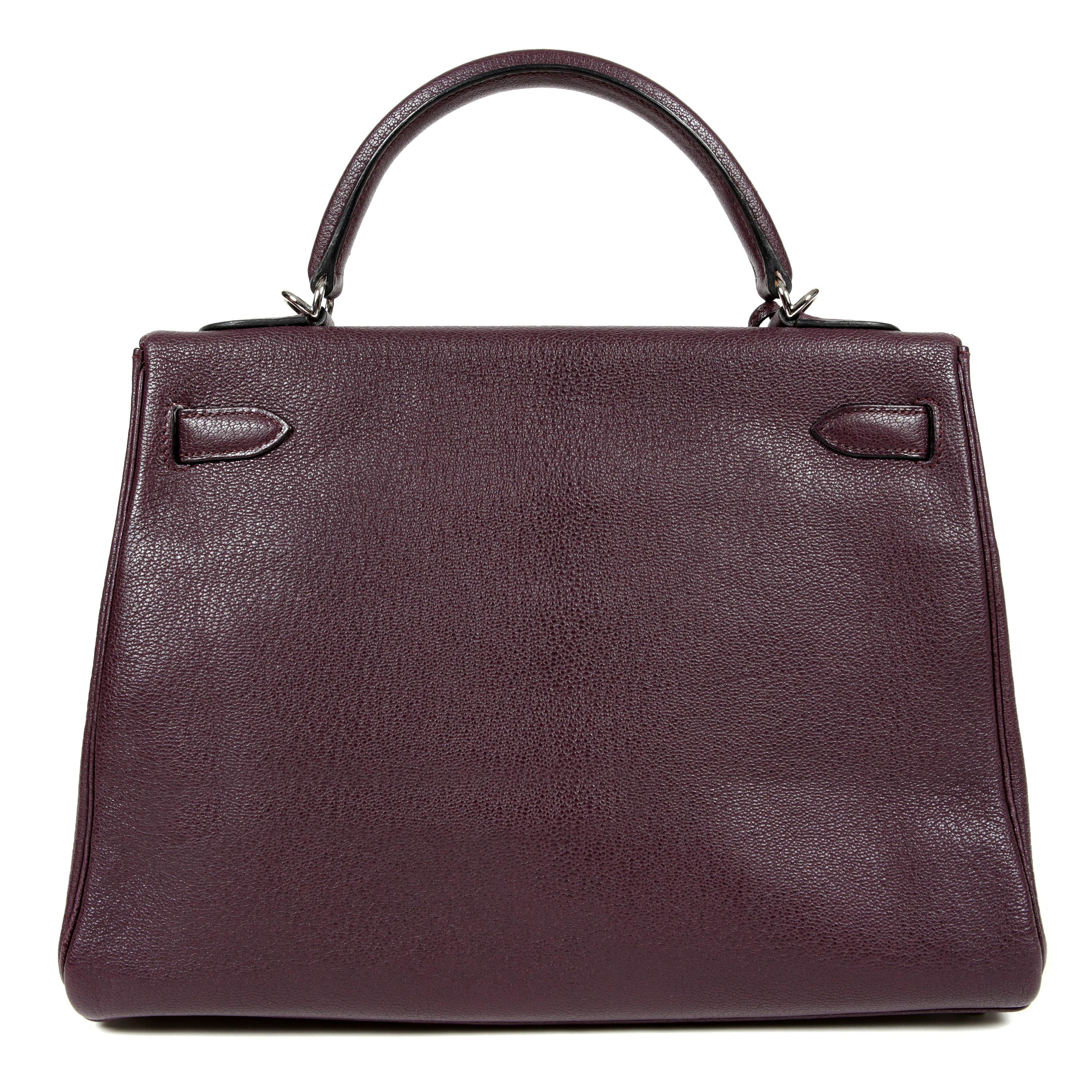 This authentic Hermès Plum Chevre Leather 32 cm Kelly is in pristine condition. Hermès bags are considered the ultimate in luxury worldwide. Each piece is handcrafted with waitlists that can exceed a year or more. The ladylike Kelly is classic and