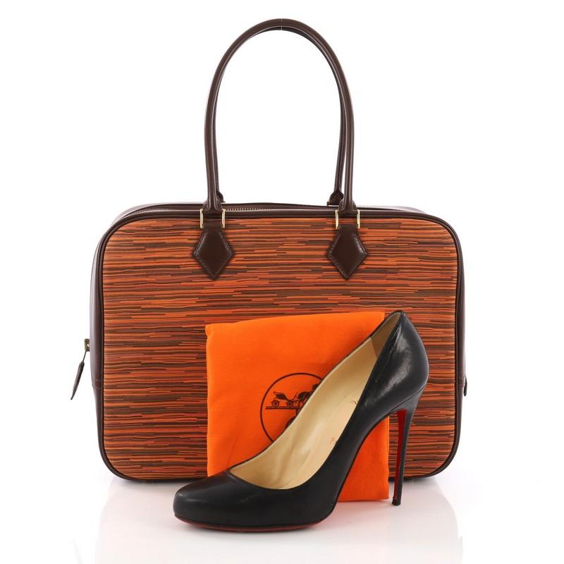 This Hermes Plume Bag Vibrato and Leather 32, crafted in multicolor vibrato and havane box calf leather, features dual rolled handles and gold-tone hardware. Its zip closure opens to a brown leather interior with slip pockets. Date stamp reads: E