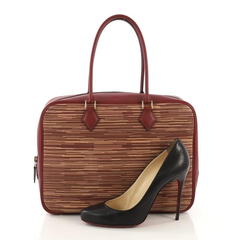 This Hermes Plume Bag Vibrato and Leather 32, crafted in Rouge H red Chamonix leather and Multicolor Vibrato, features dual rolled handles and gold hardware. Its zip closure opens to a Rouge H red Chevre leather interior with slip pockets. Date