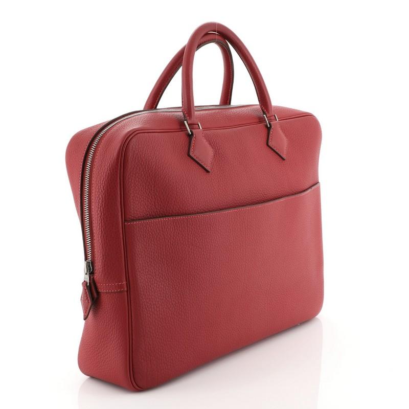 This Hermes Plume Doc Bag Buffalo 38, crafted in Rouge Vif red Buffalo Skipper leather, features dual rolled handles and palladium hardware. Its zip closure opens to a Rouge Vif red Buffalo Skipper leather interior with slip pockets. Date stamp