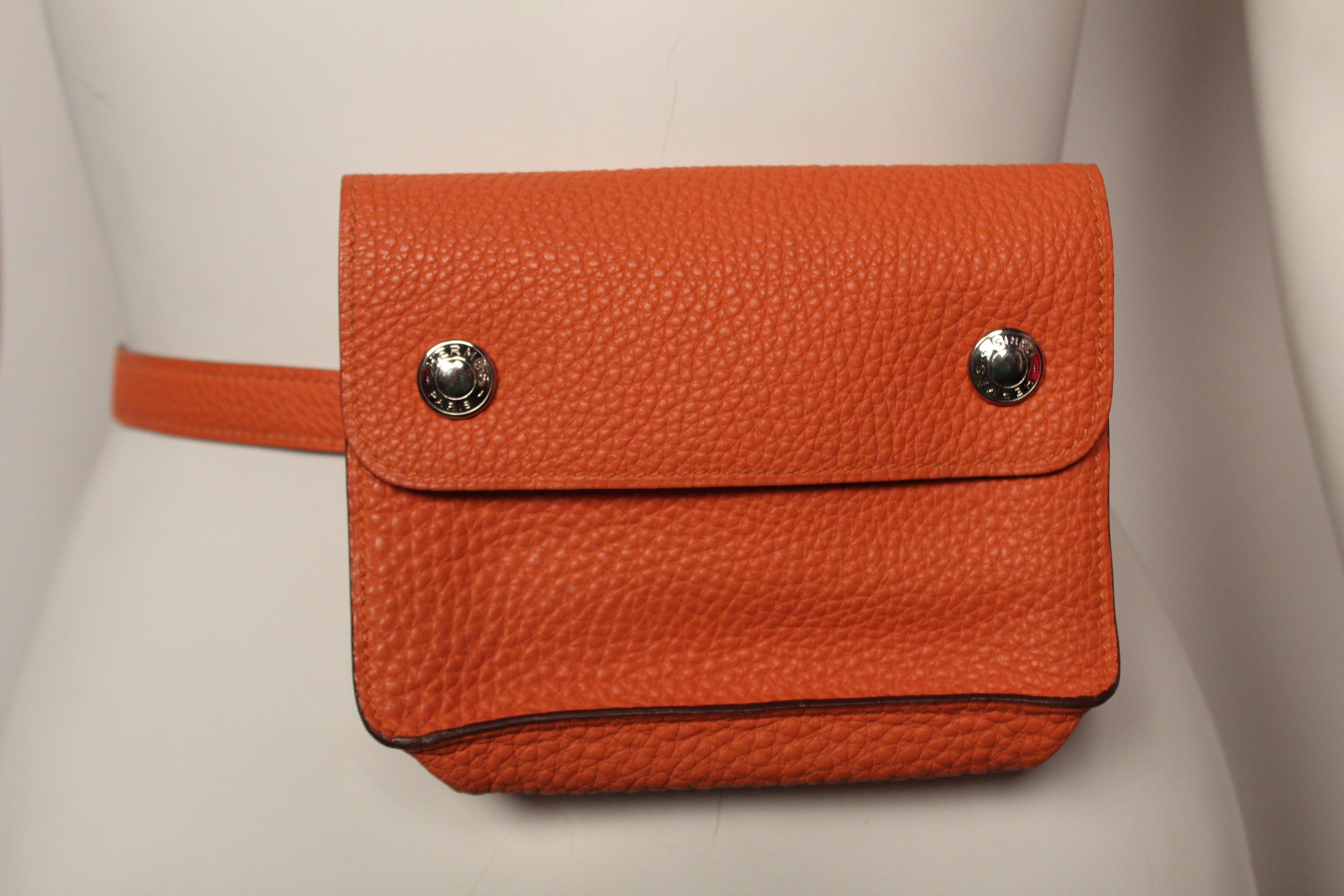 Hermès Pochette Green waist bag in velvety soft orange clemence leather with silver toned hardware, single flat waist strap with silver belt loop closure to provide felxible sizing and dual snap closures at front flap.

