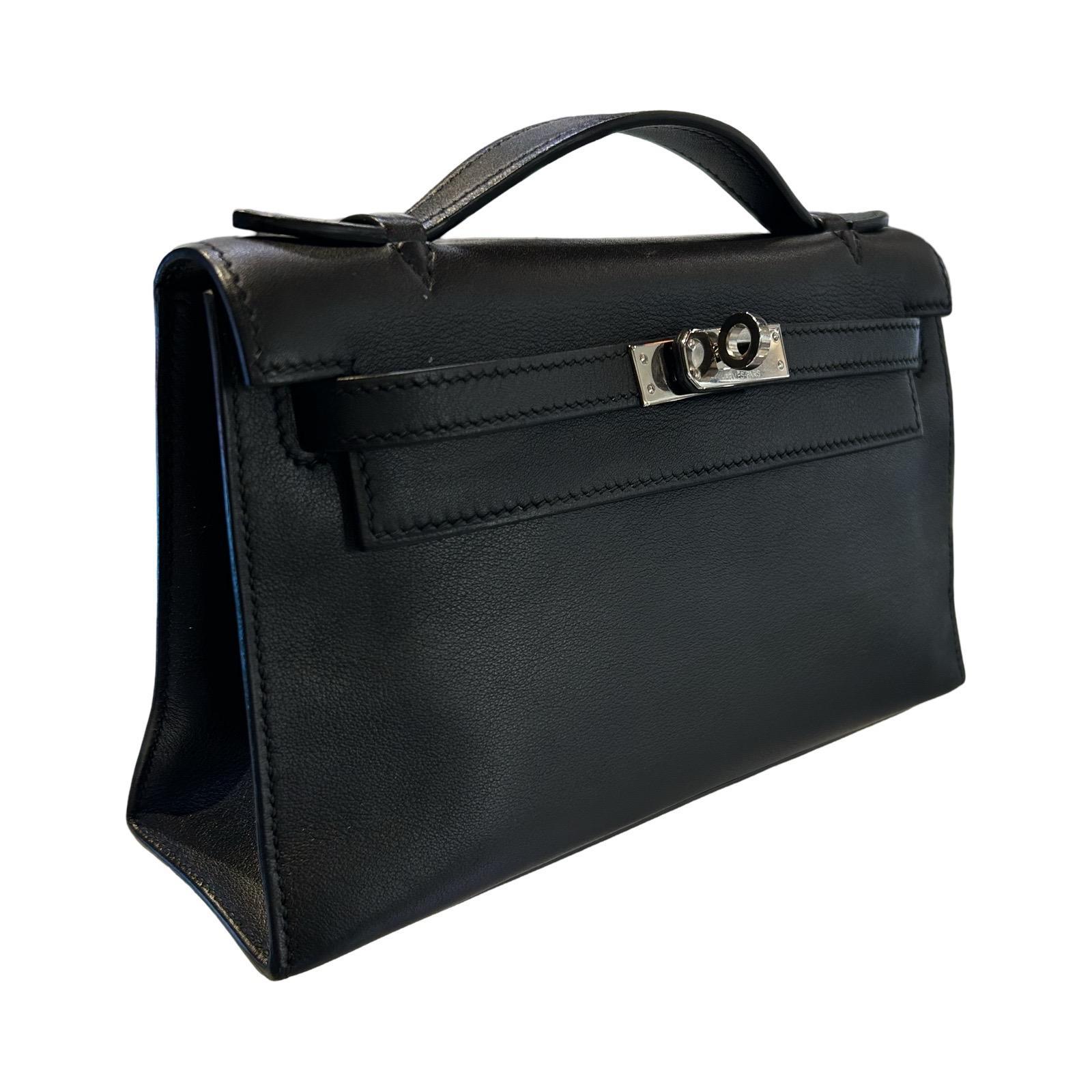 Cette pochette Kelly noire d'Hermès est fabriquée en cuir souple et dotée de ferrures en palladium. Il est doté d'une poignée supérieure élégante de 1 pouce, d'une sangle et d'une fermeture à verrou tournant. Le rabat avant s'ouvre sur un intérieur