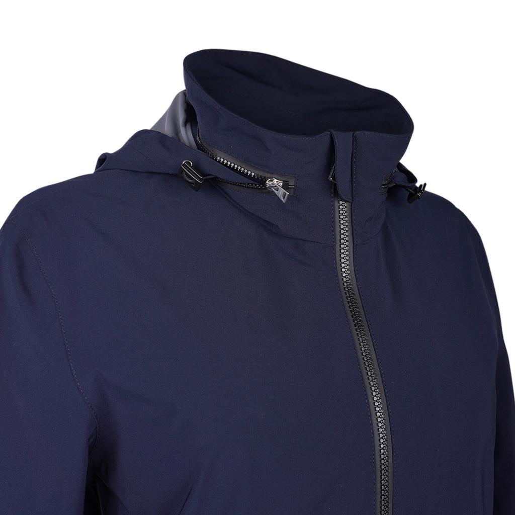 Mightychic offers an  Hermes Ponant Waterproof Jacket featured in Navy.
Light and breathable, the jacket is waterproof and weather resistant.
Hoodie can be hidden in zipper at rear of neck.
Front zip with iconic embossed stirrup pull.
Waterproof