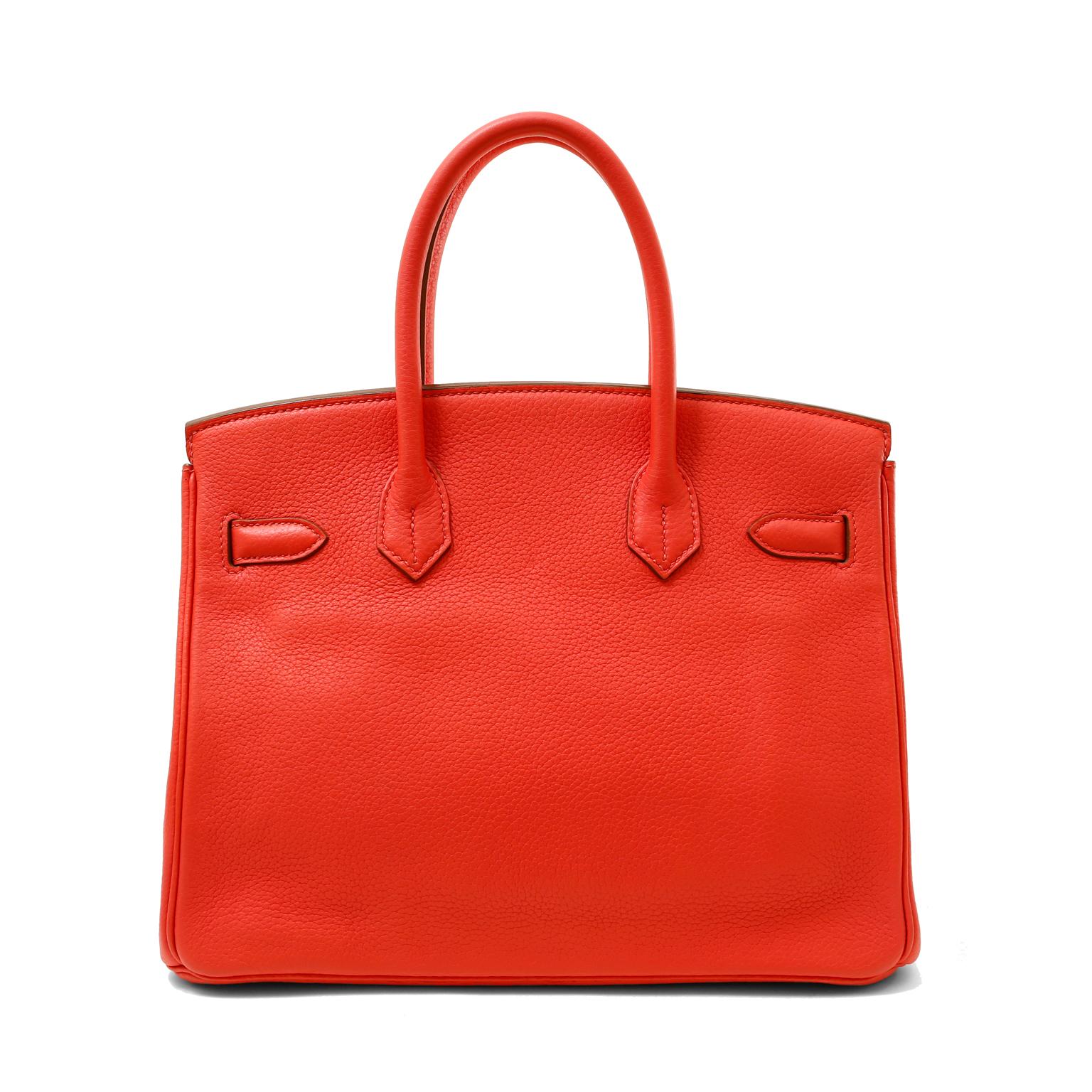 This authentic Hermès Poppy Red Togo 30 cm Birkin is in pristine unworn condition with the protective plastic intact on the hardware.  Beautifully warmed by gold hardware, the combination is captivating.
Textured and durable bright Poppy Togo