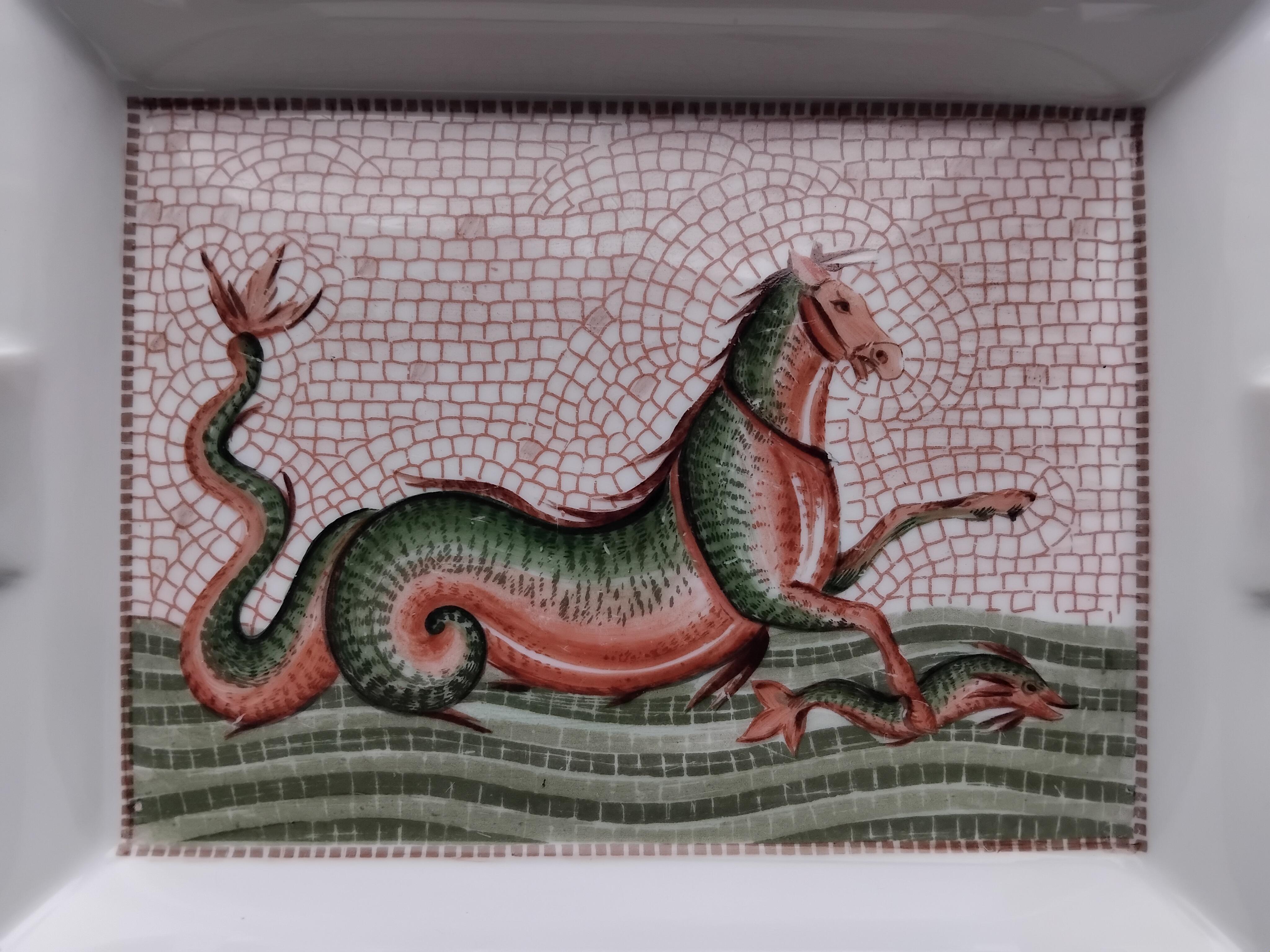 Bellissimo e raro posacenere autentico di Hermès

Stampa: Cavalluccio marino

Questo disegno ispirato alla mitologia greca rappresenta il cavallo marino con una testa di cavallo, due zampe anteriori e una coda ispirata a un pesce o a un