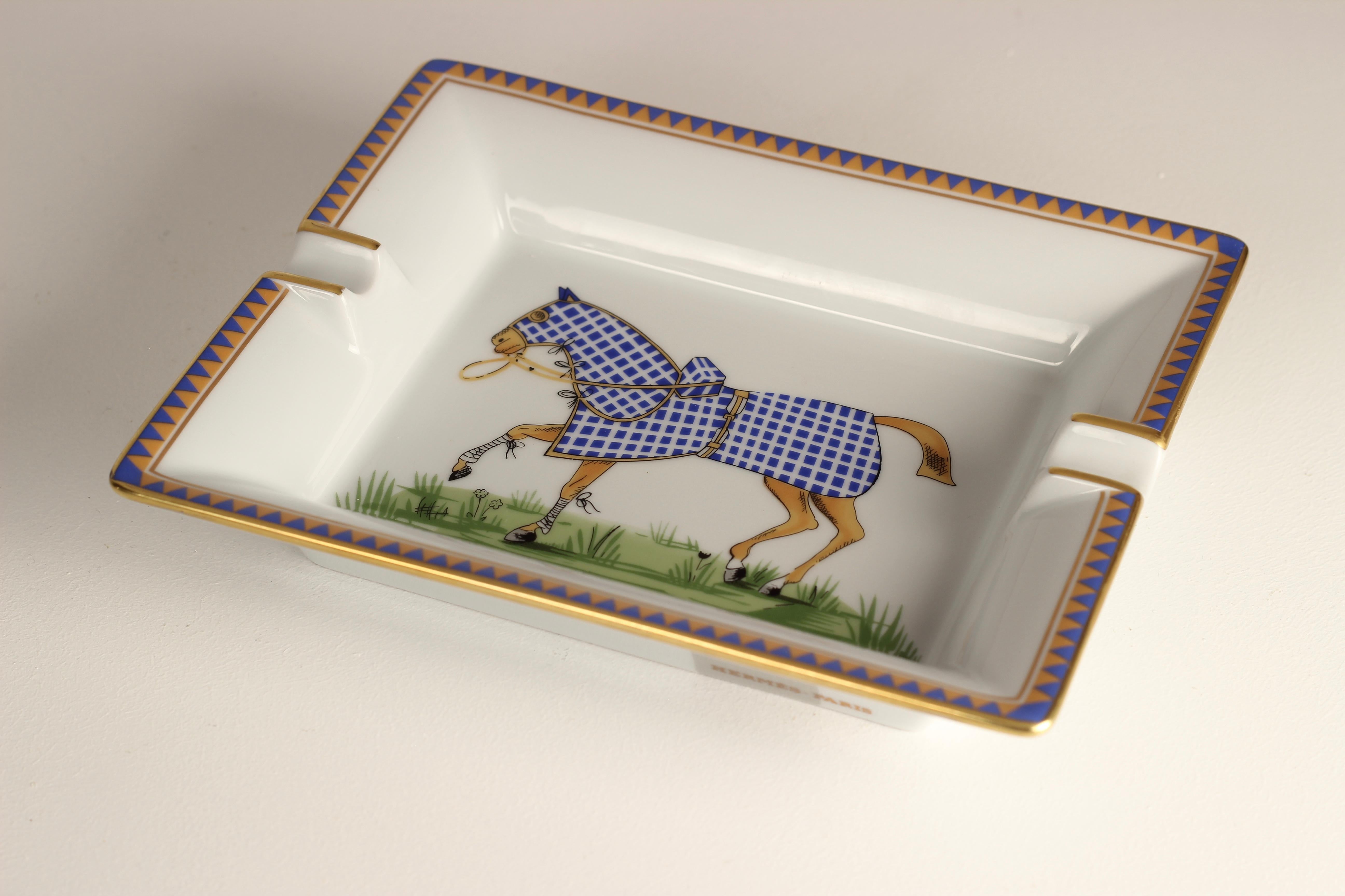 A fine example of Hermès design and its enduring craftsmanship. This Porcelain Ashtray would also serve well as a key or loose change Tray Vide-Poche Catchall. Exquisitely coloured with a study of a finely detailed racing horse wearing a graphically