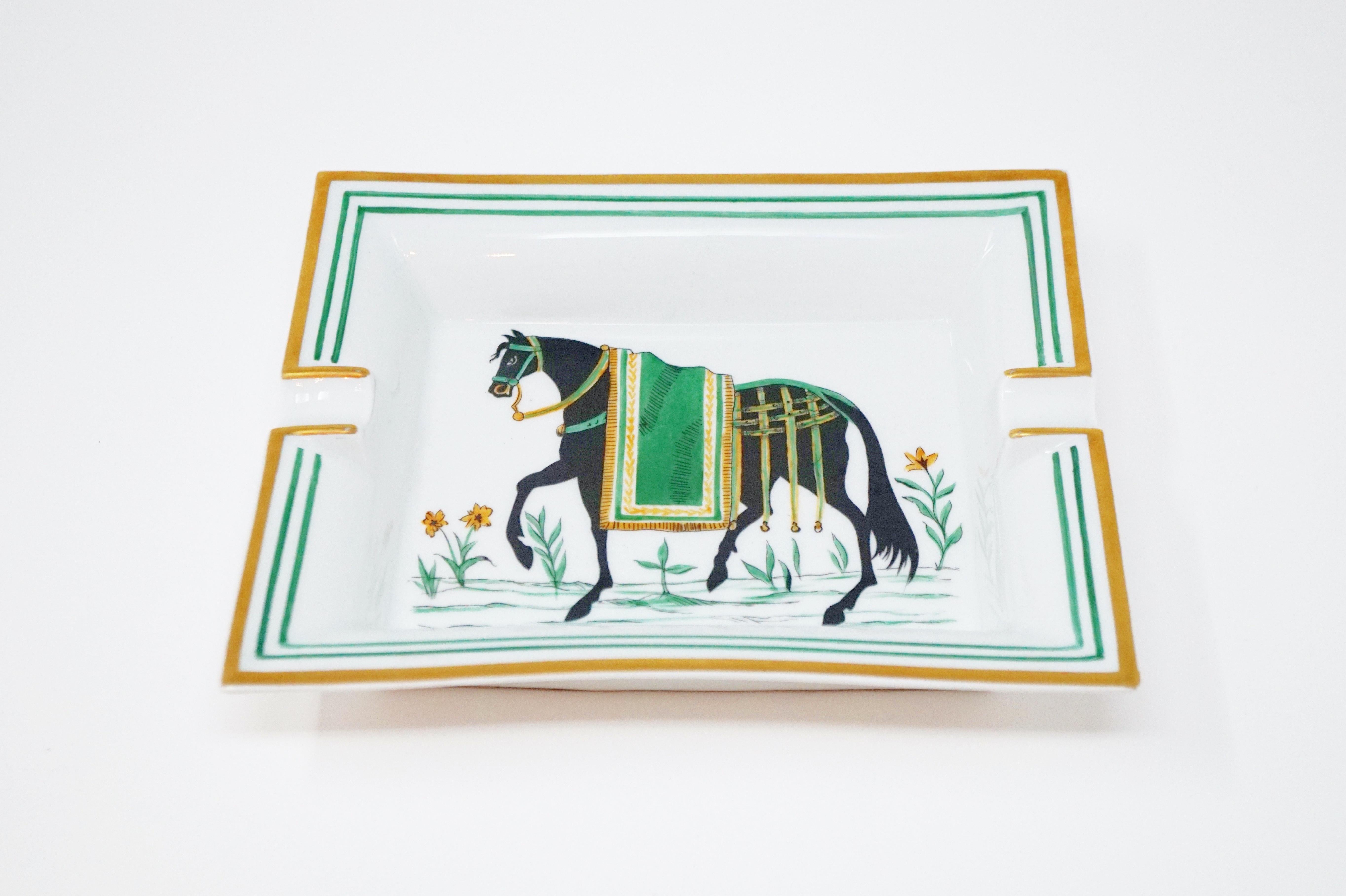 Beautiful Hermès porcelain ashtray with Classic equestrian design and gold leaf detail.

Marked 