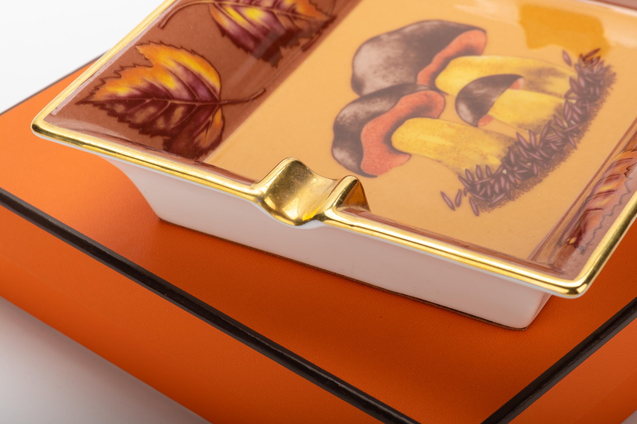Hermès brown and gold porcelain ashtray with collectible mushroom design. Bottom natural tone suede. Excellent condition. Comes with original box.